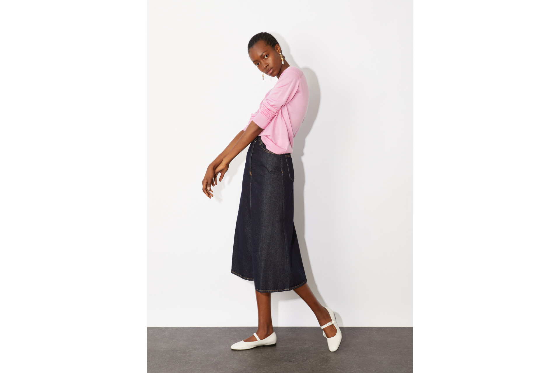 Woman in pink cardigan and denim skirt