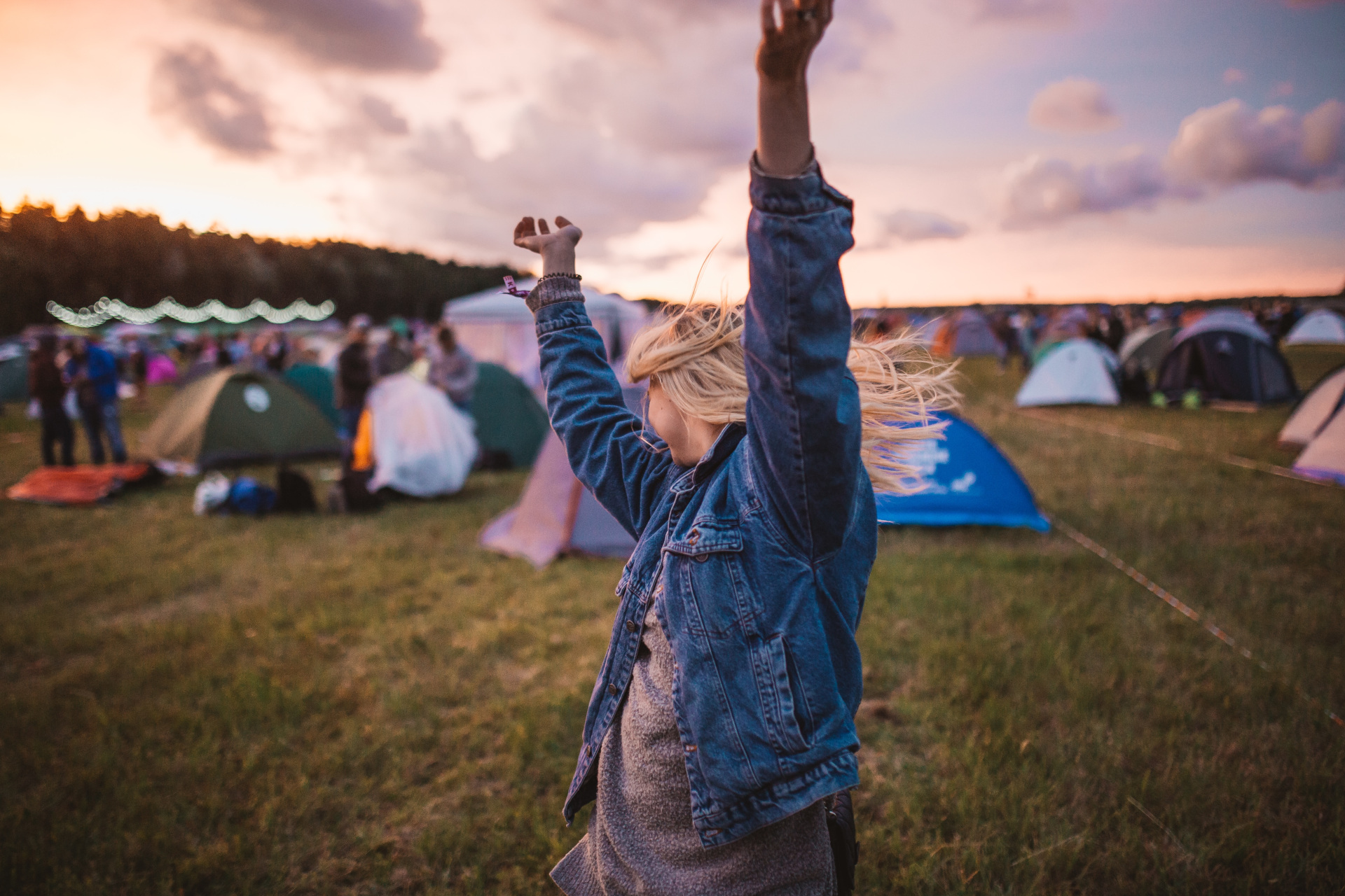 Woman dancing in front of festival tents