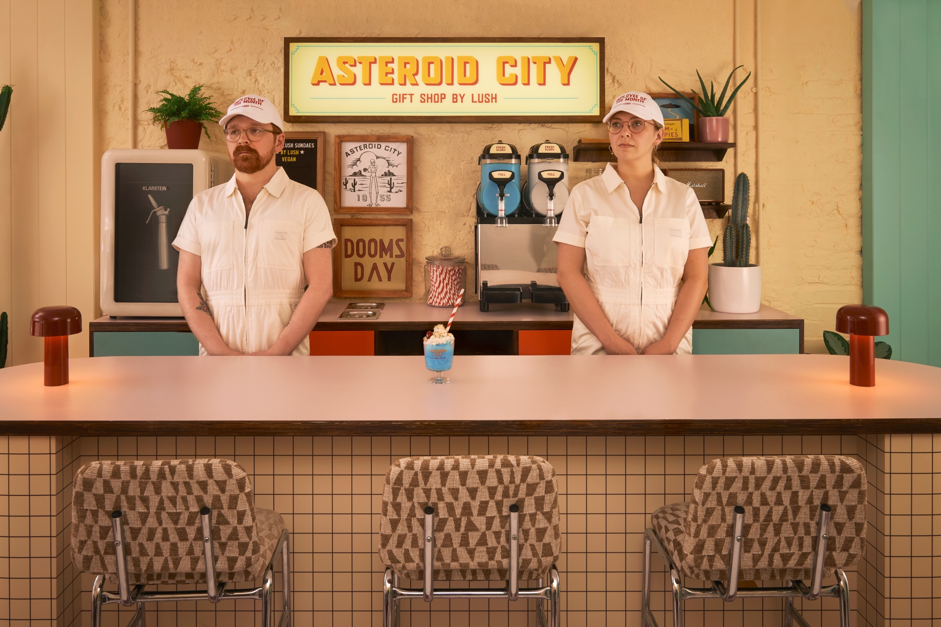 People stood behind Wes Anderson style bar