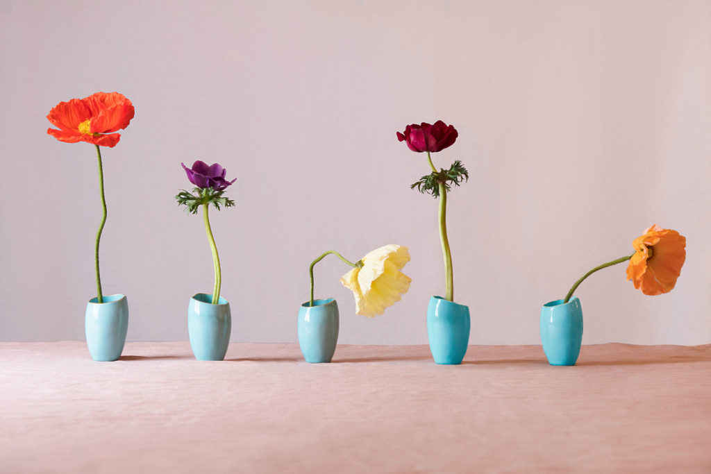 Row of blue vases with flowers