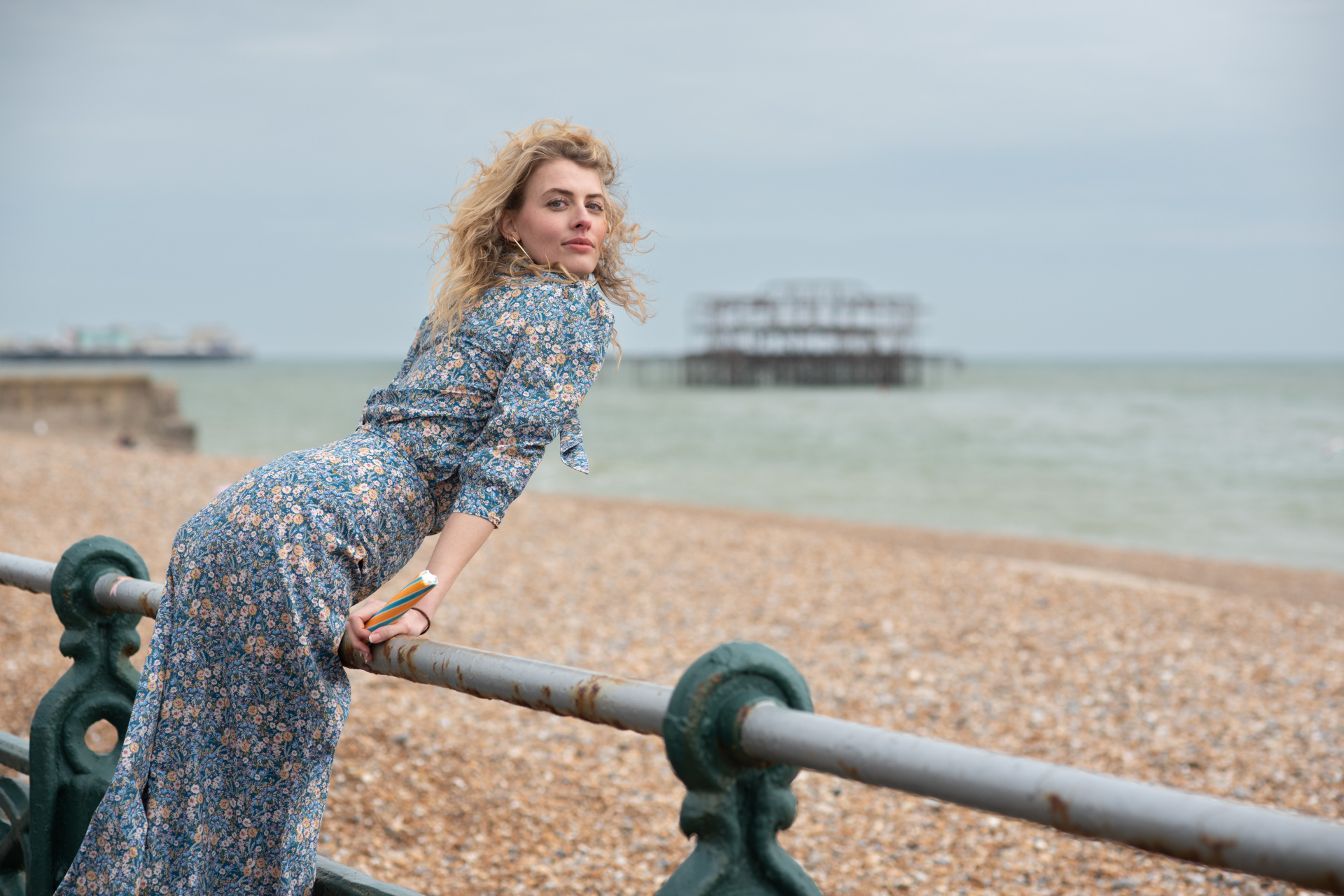 Woman leaning on rail overlooking beach