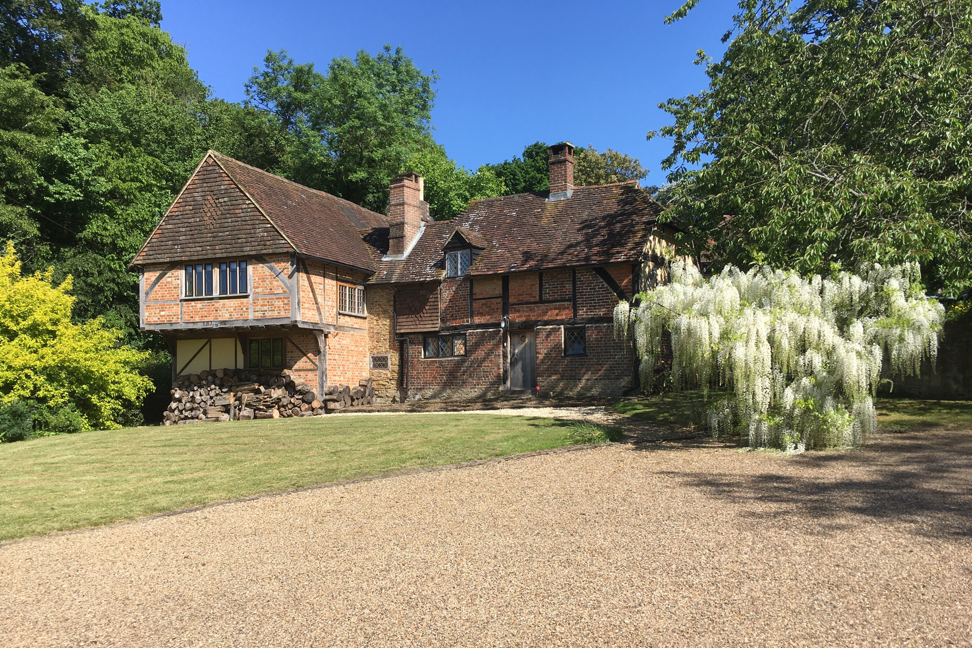 16th century cottage with a gravel driveway.