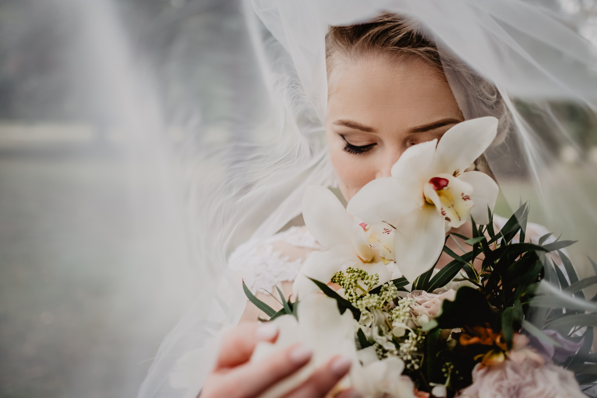 Bride with face and skin half covered by bouquet