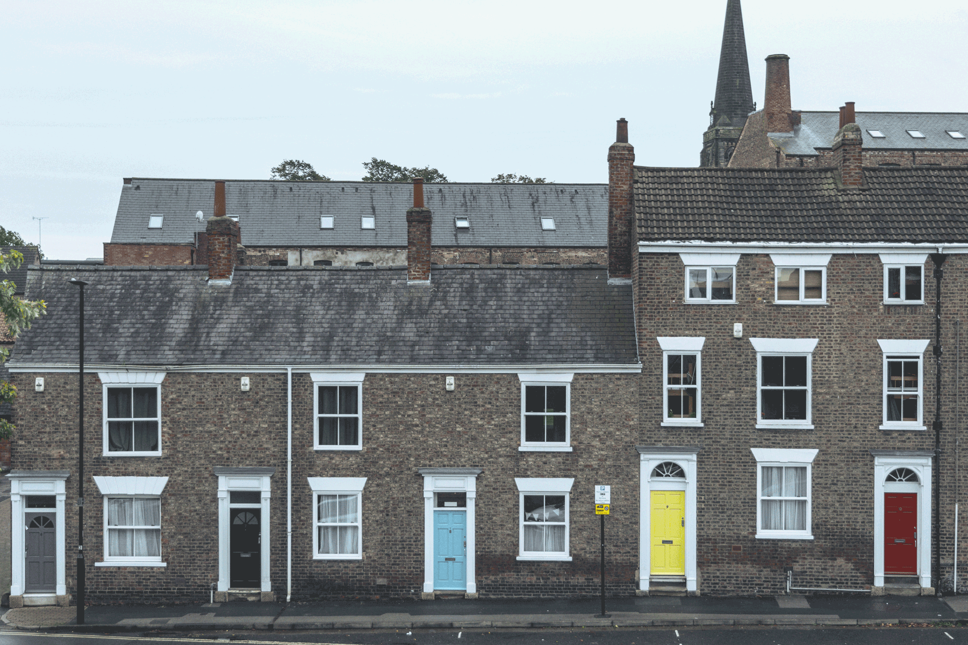 Brick terraced houses with colourful front doors.