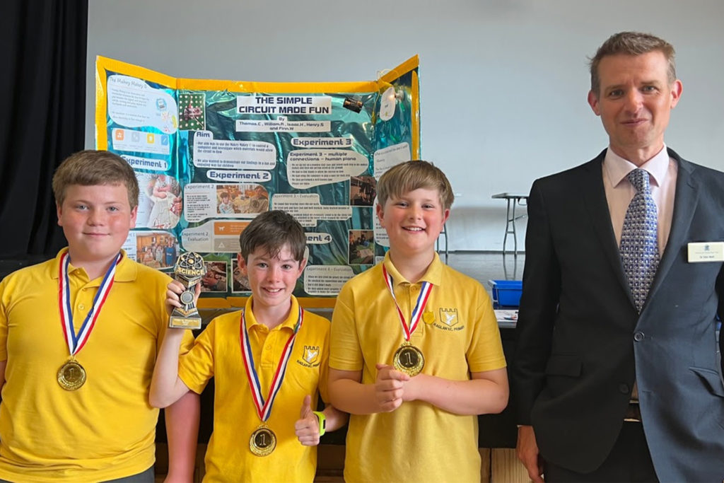 Raglan Primary School pupils celebrate their trophy success with event organiser, Dr Sion Wall, from Monmouth Prep School.
