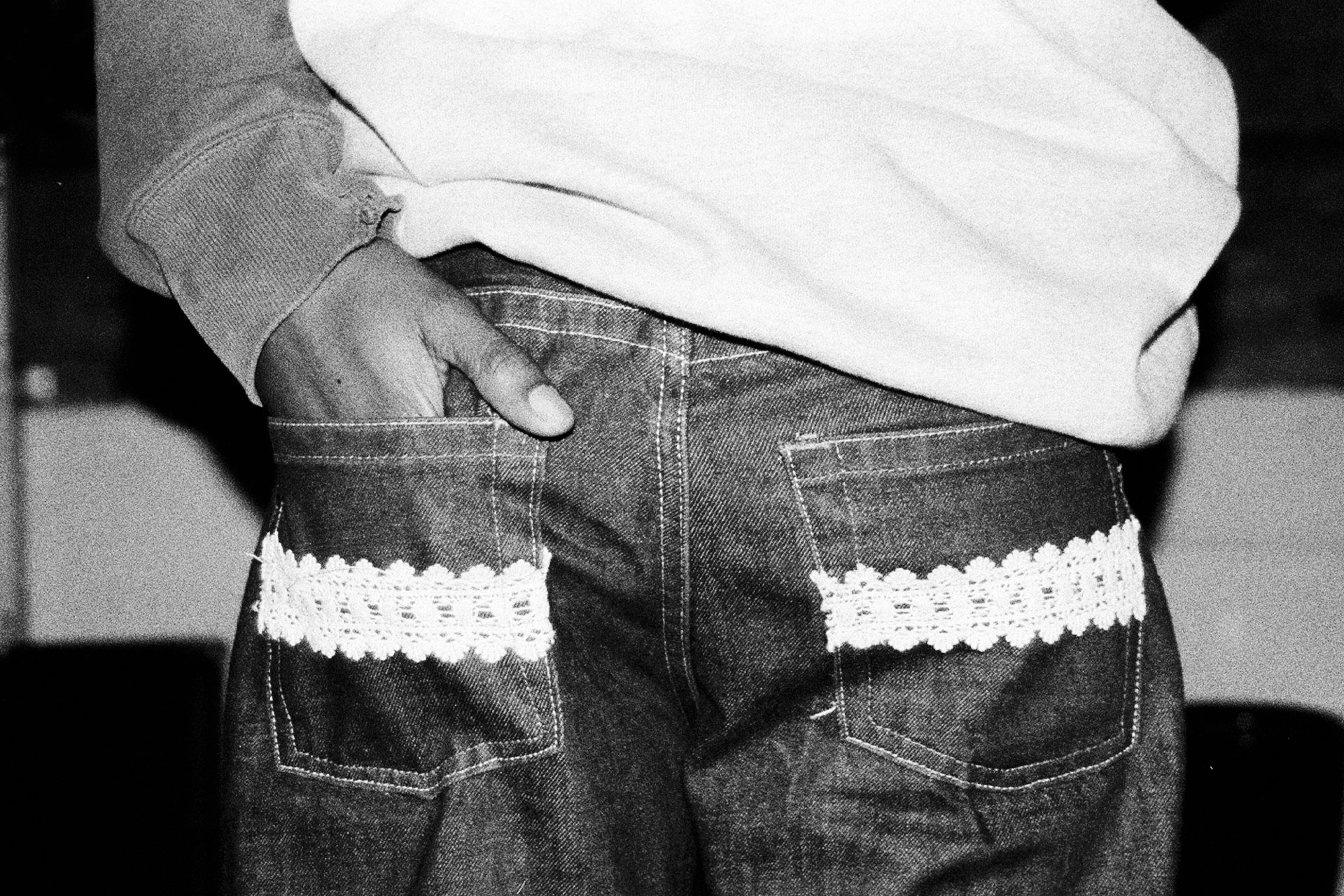 A black and white photo of a man's hand in his pocket