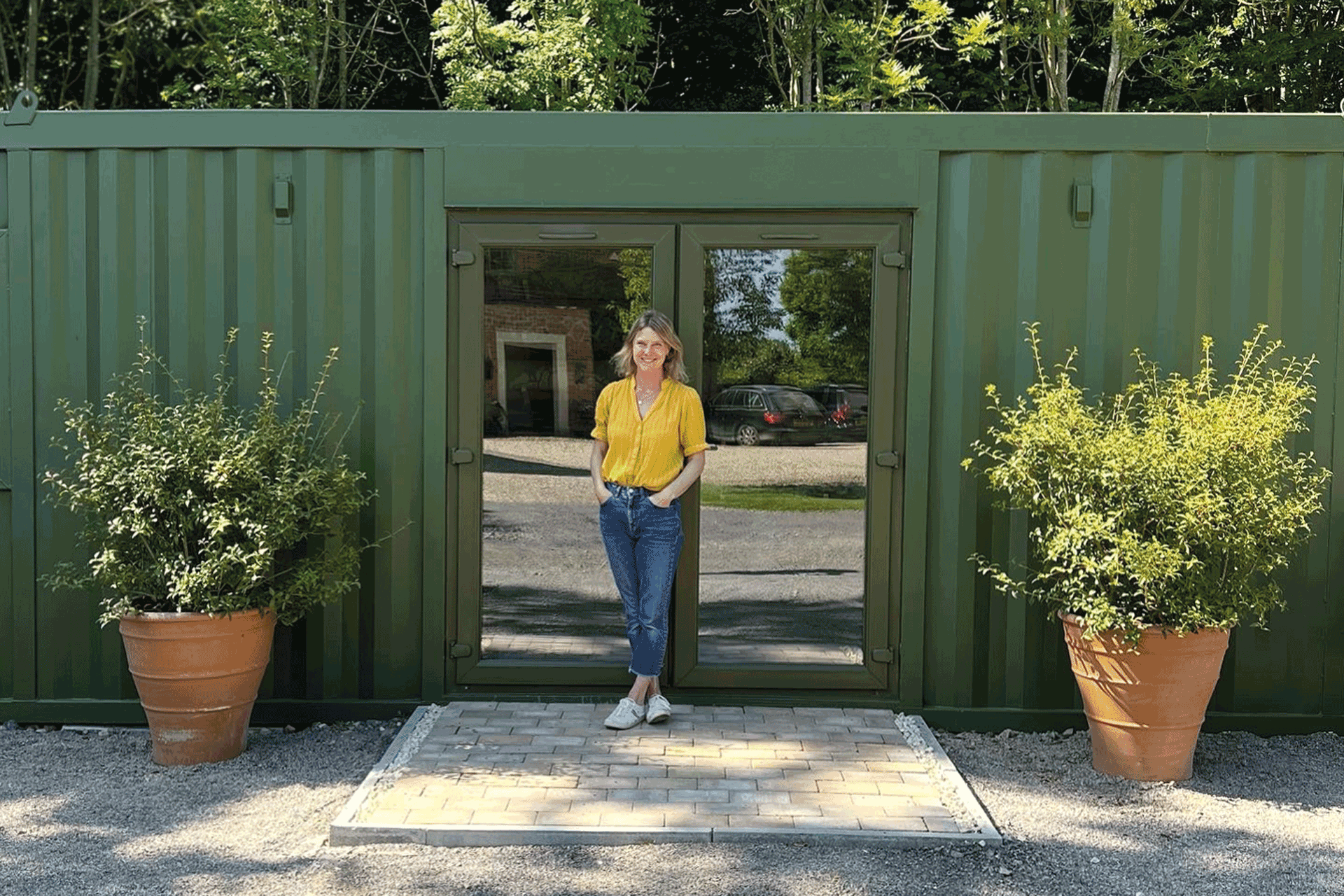 Amy Kent in front of a forest-green warehouse.