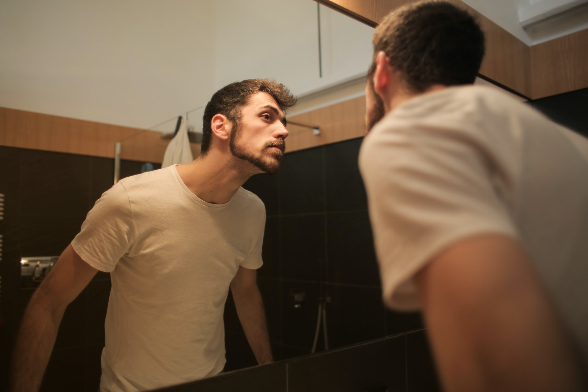 Man looking at face in mirror