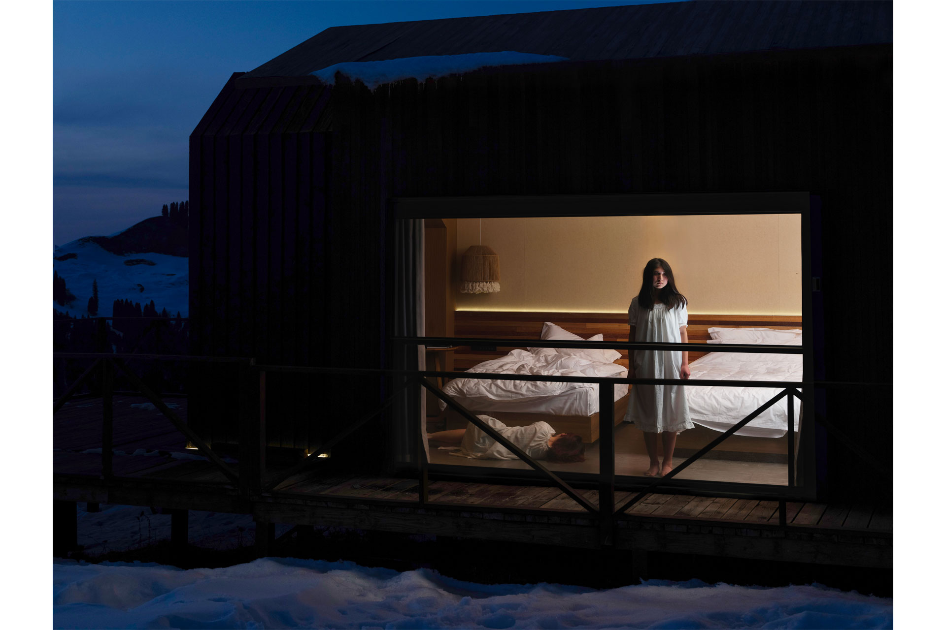 A woman stood in her bedroom, seen from outside the window