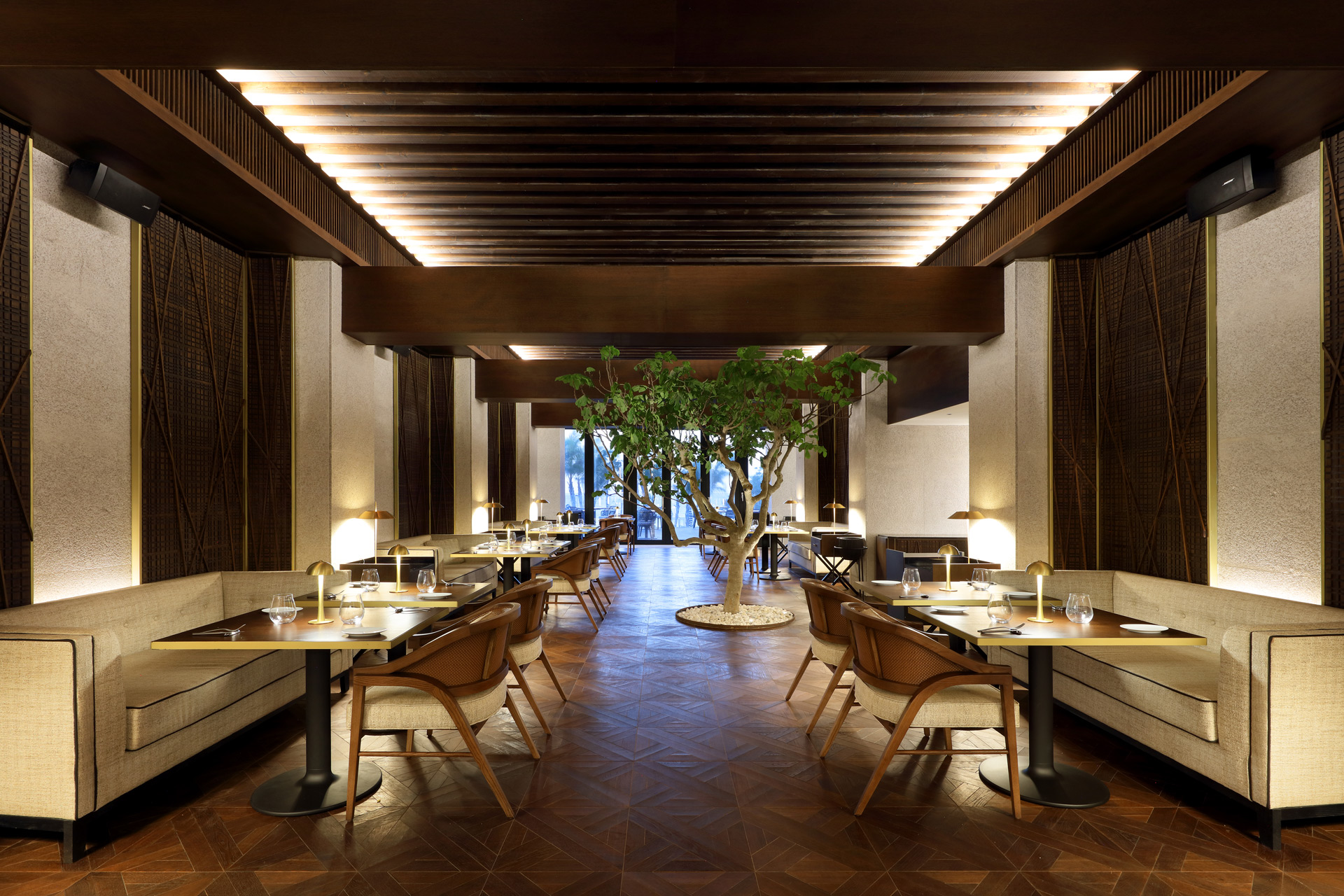 Restaurant at Bless Hotel Ibiza featuring rectangular cream sofas and square tables.