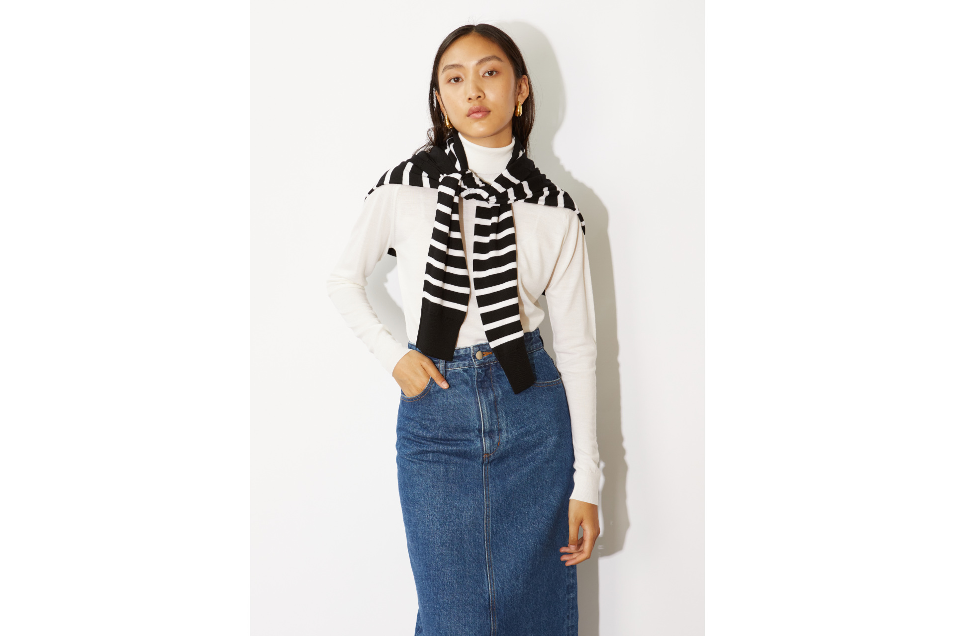 Woman in white top, stripe jumper and denim skirt
