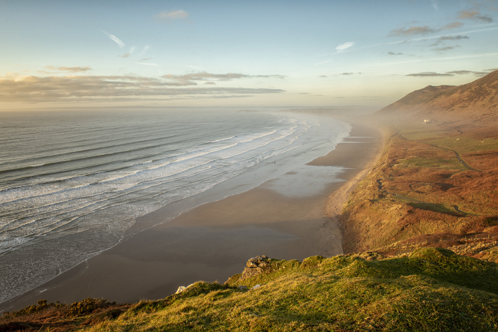 Landscape image of Rhossili Bay beach, South Wales at sunset
