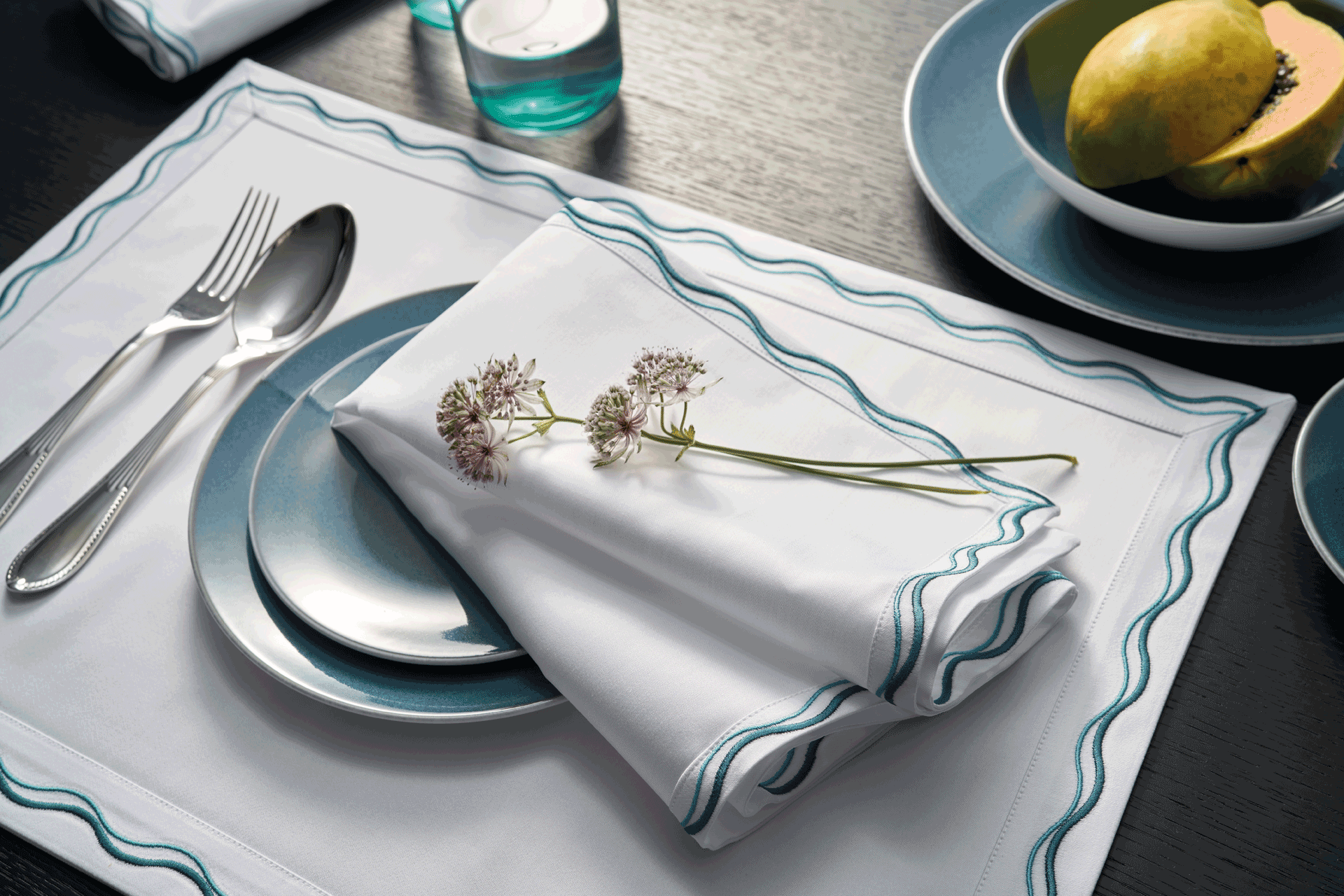 Tablescape with blue-tipped placemat and napkin