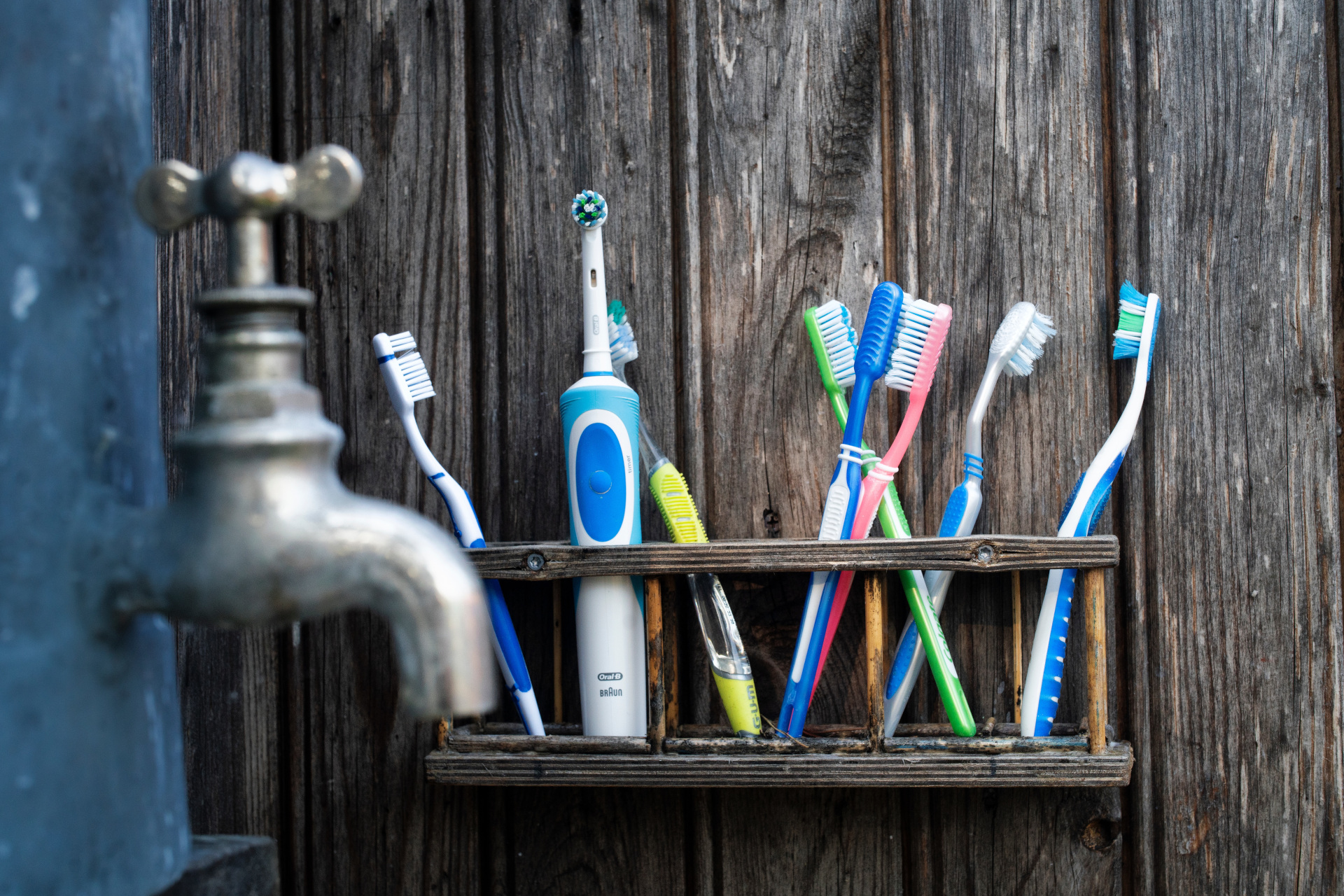 Toothbrushes in basket by tap
