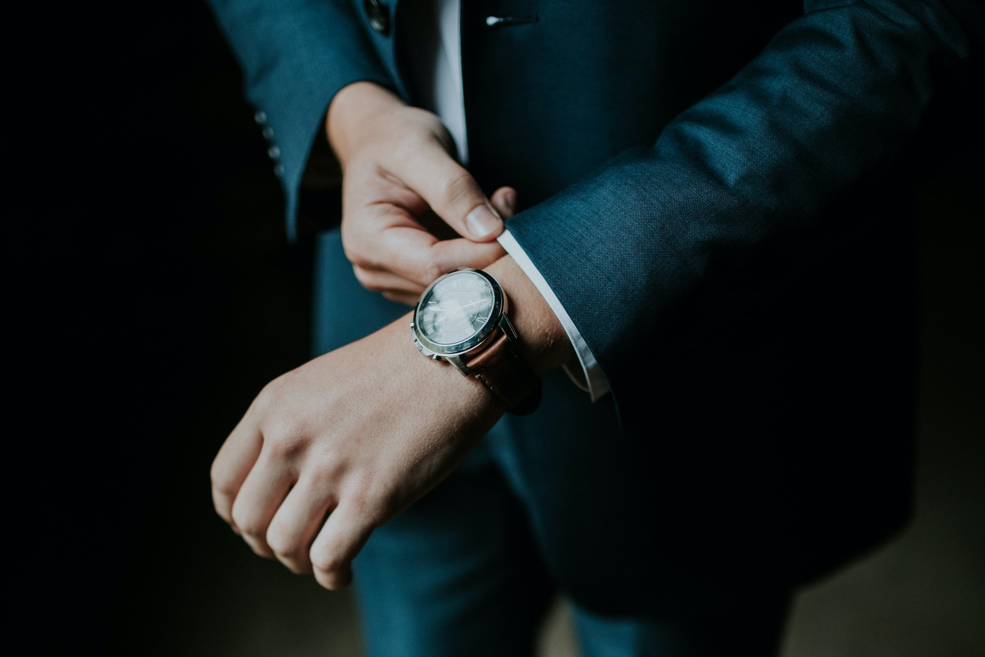 Close up of man in suit adjusting watch