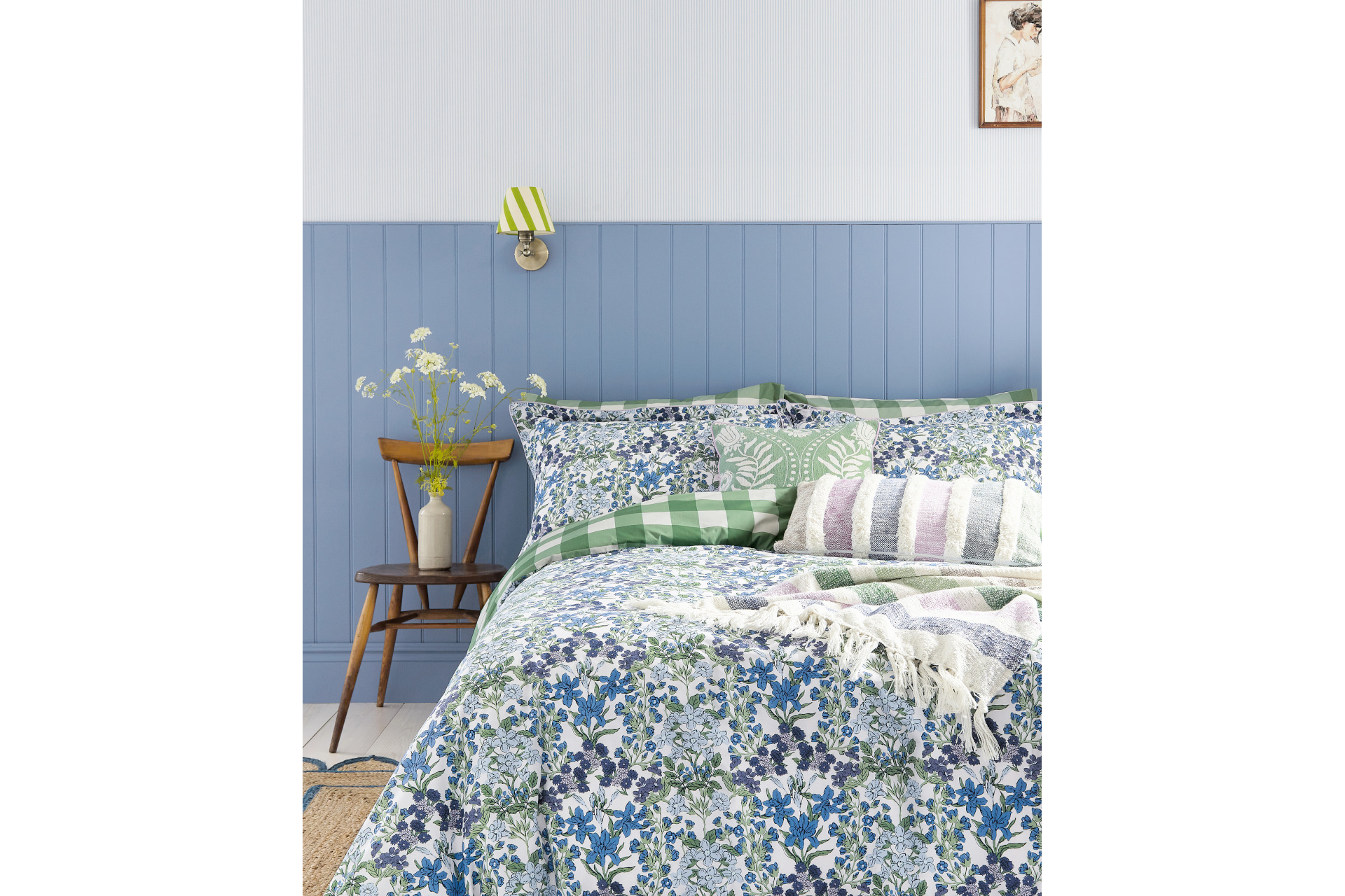 Made up bed with blue sheets and wall