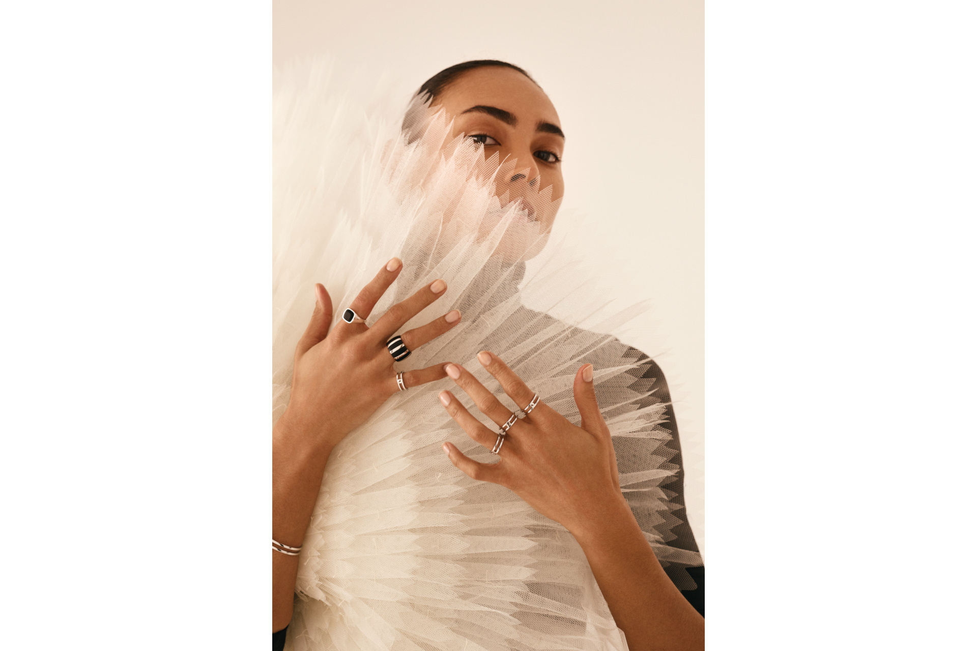 Woman holding tulle fan while wearing rings