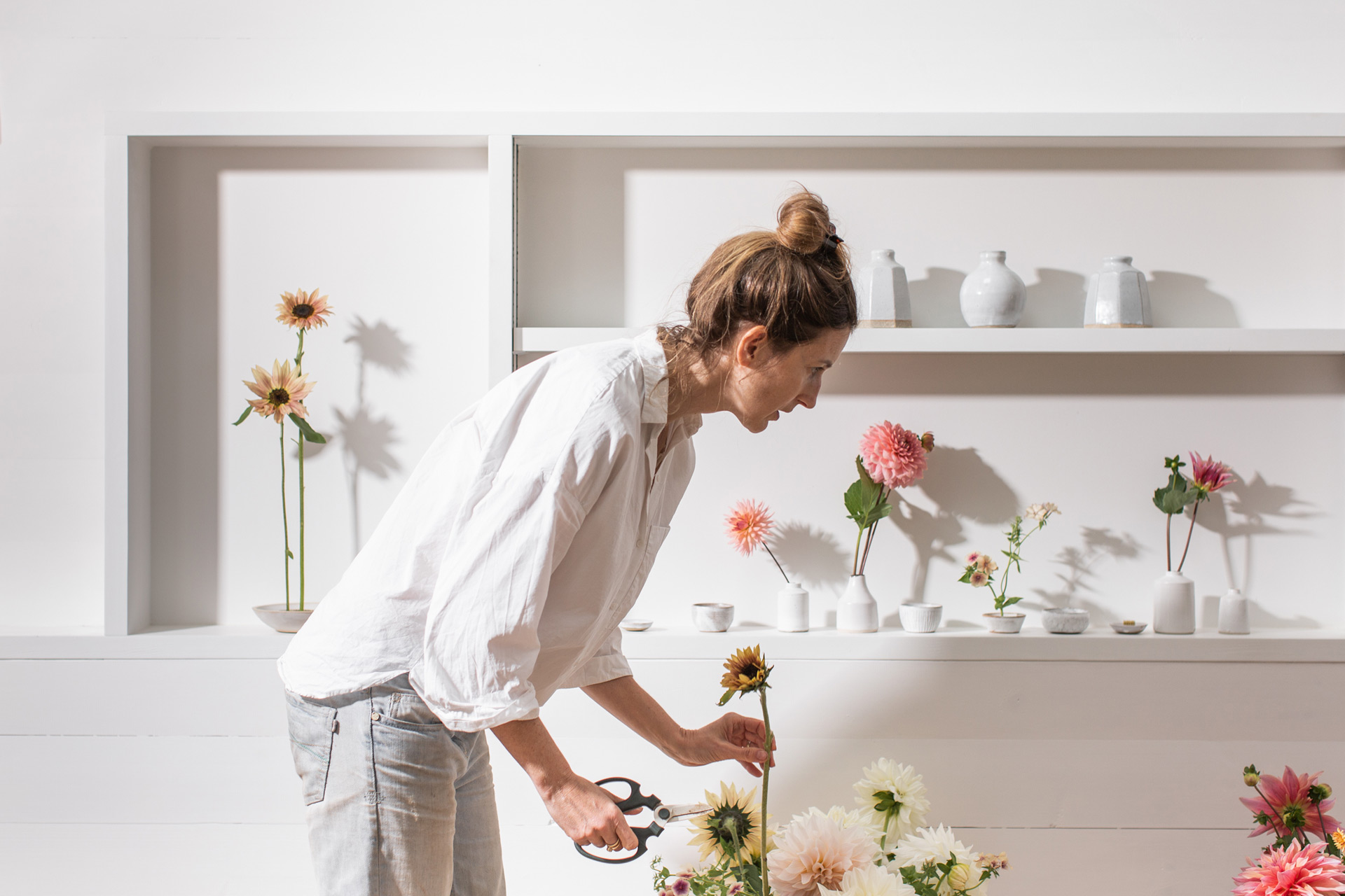 Stephanie Woolvett wearing a white shirt cutting flower stems