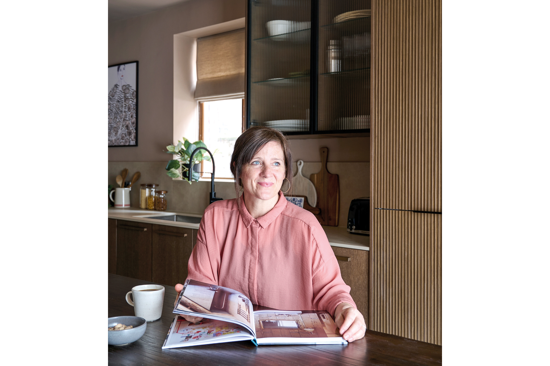 Pippa Jameson sitting in kitchen with her book The Sensory Home
