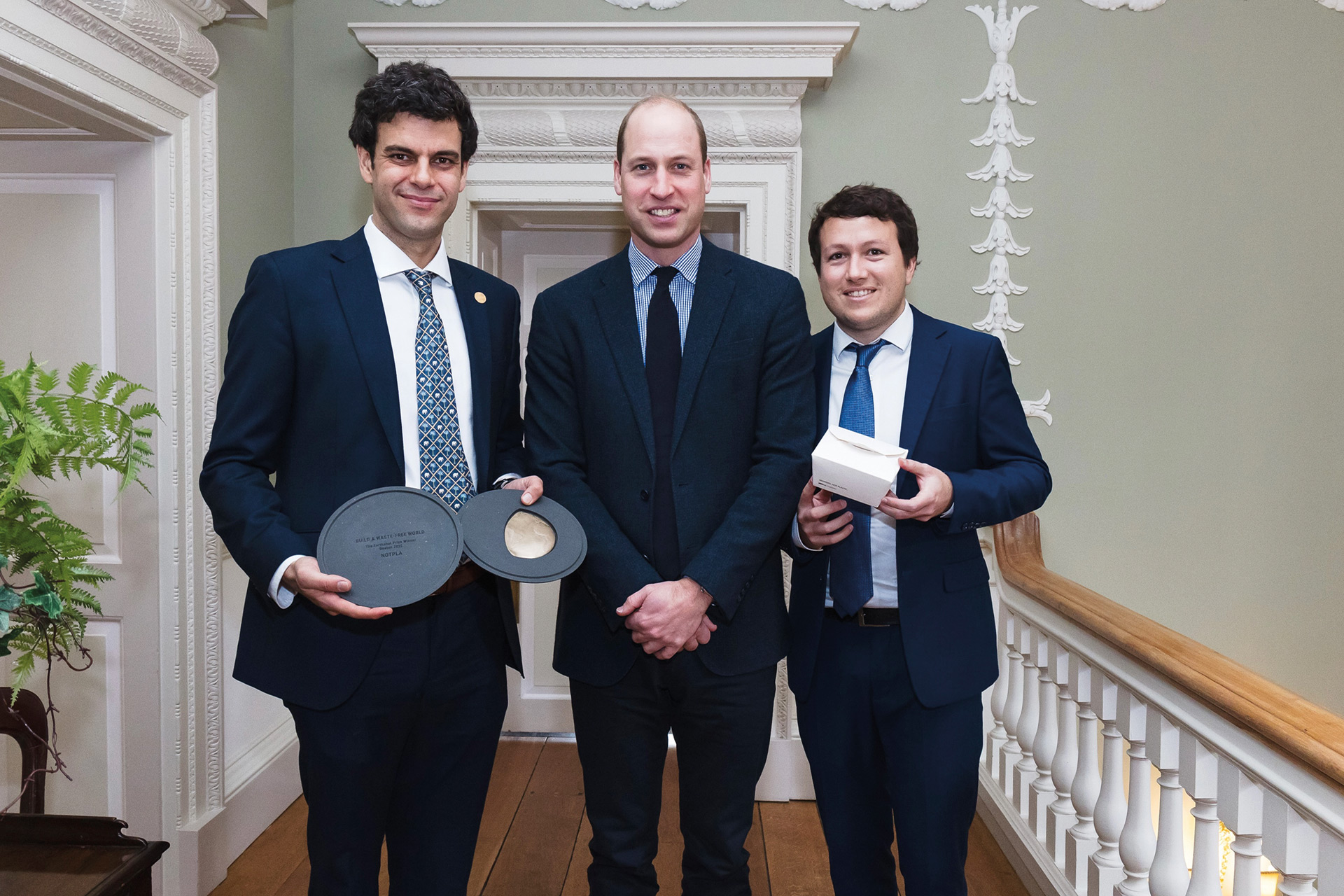 Notpla founders holding their trophies next to Prince William at the Earthshot Prize board meeting.