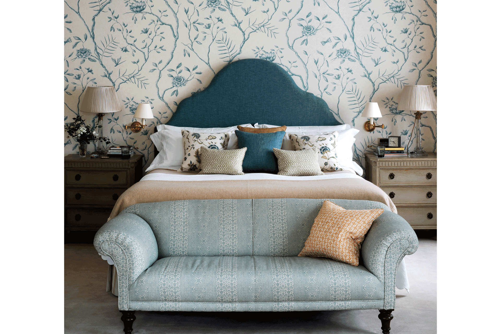 Bedroom with blue and white wallpaper, blue headboard and pale blue sofa