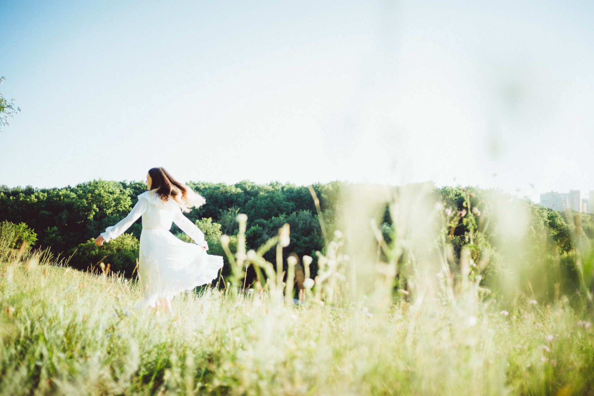 Woman in white dress running through field