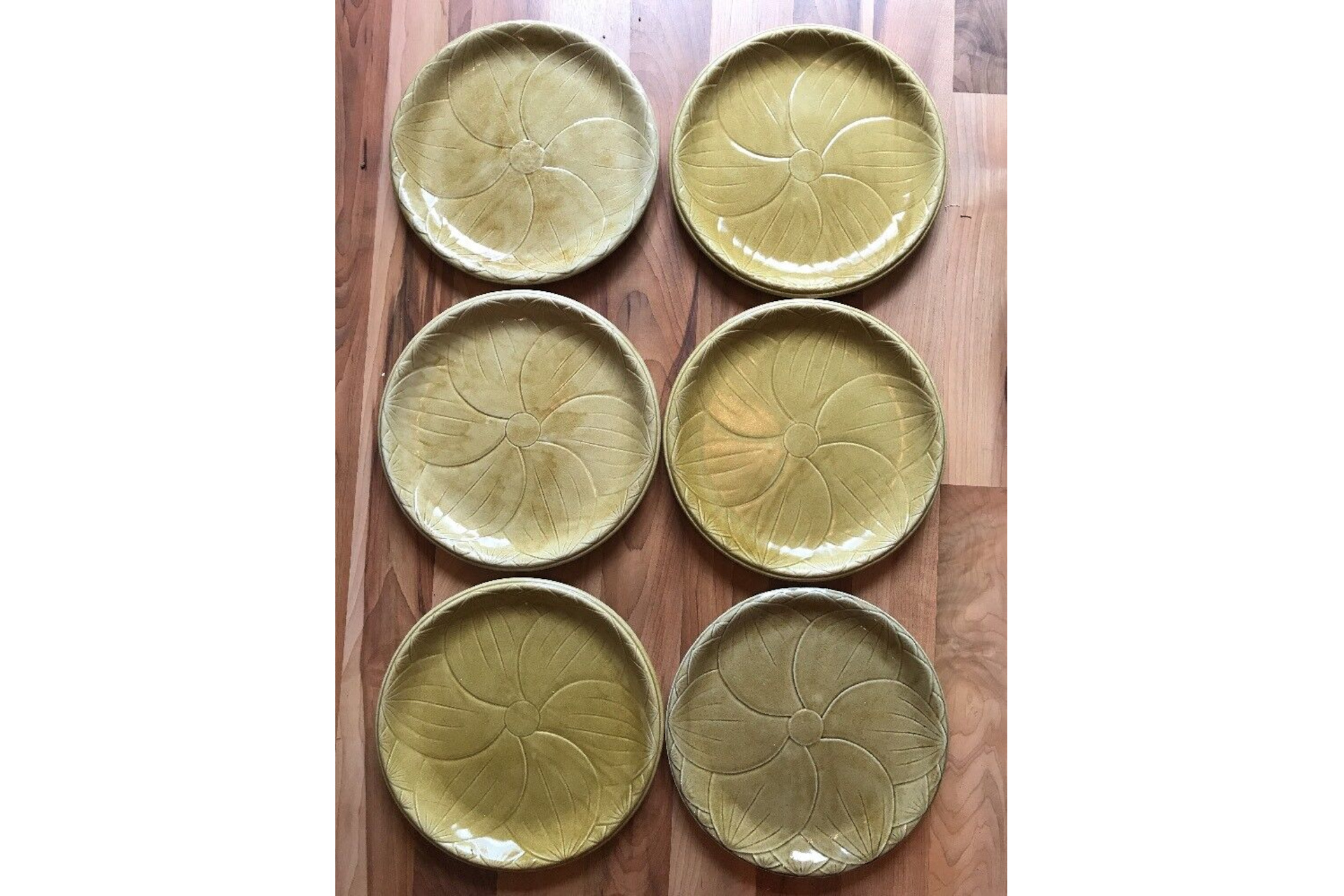 Set of six brown-green plates on table