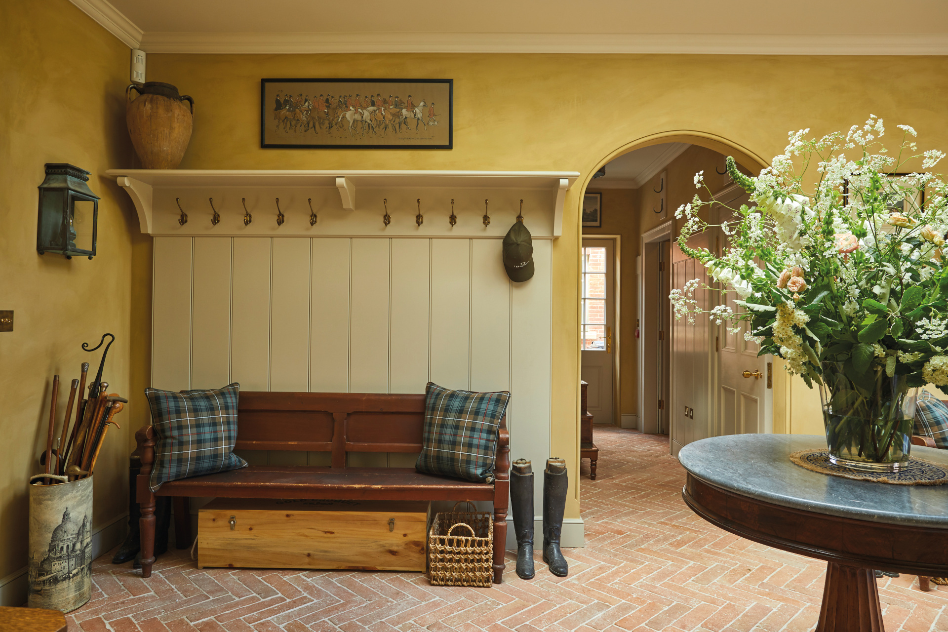 Yellow boot room with bench, wellies and coat rack