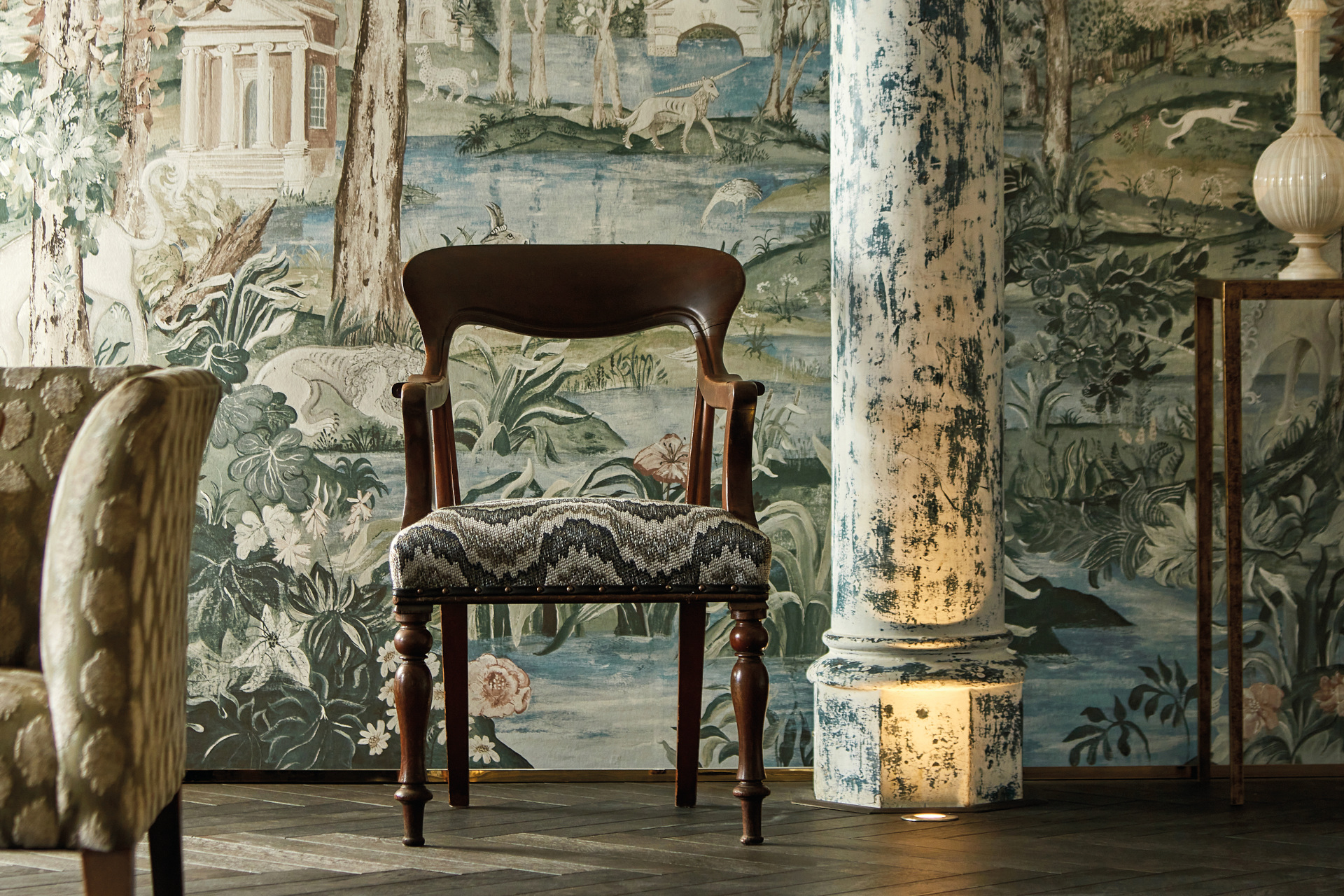Wooden chair in front of ornate wallpaper