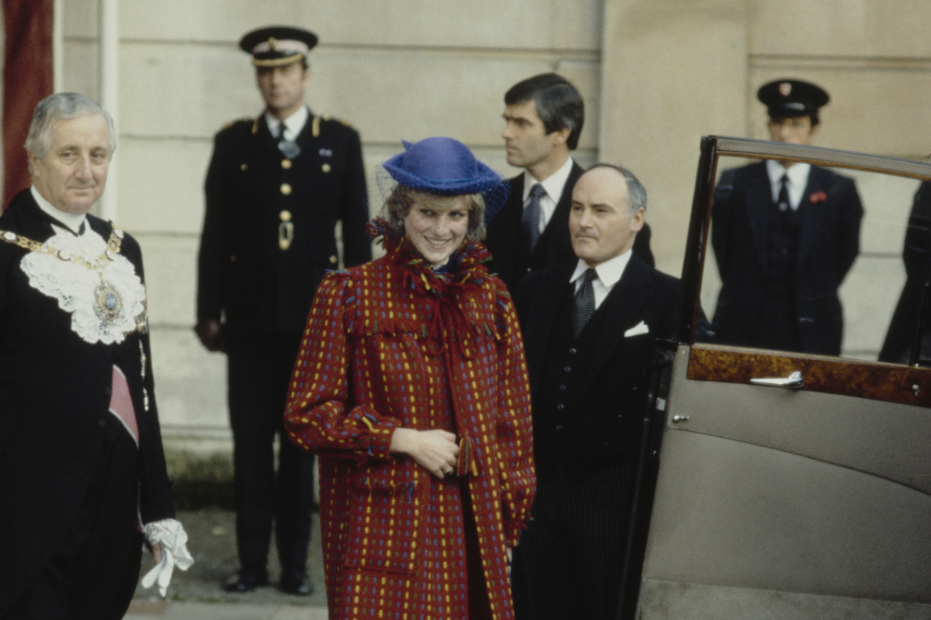 Princess Diana wearing a red coat by Bellville Sassoon and a blue hat by John Boyd, leaves the Guildhall after having lunch with the Lord Mayor in London, England, United Kingdom, November 1981.