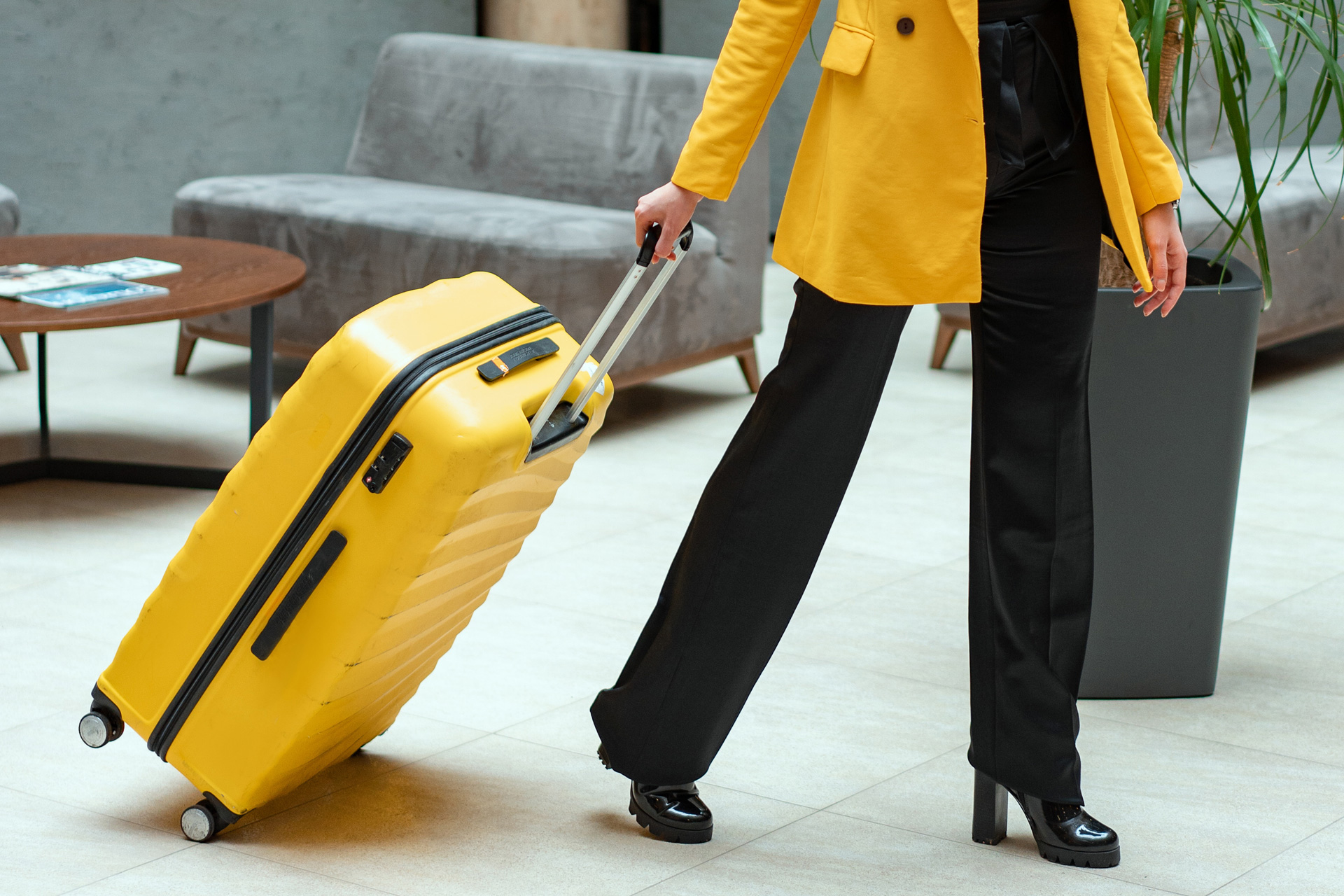 Woman with yellow suitcase walking through the airport