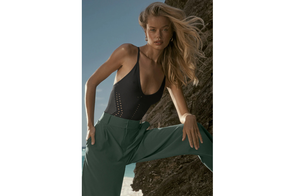 Woman in black top and green trousers