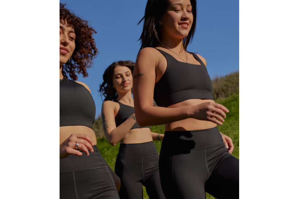 Group of women running in black bralettes and shorts