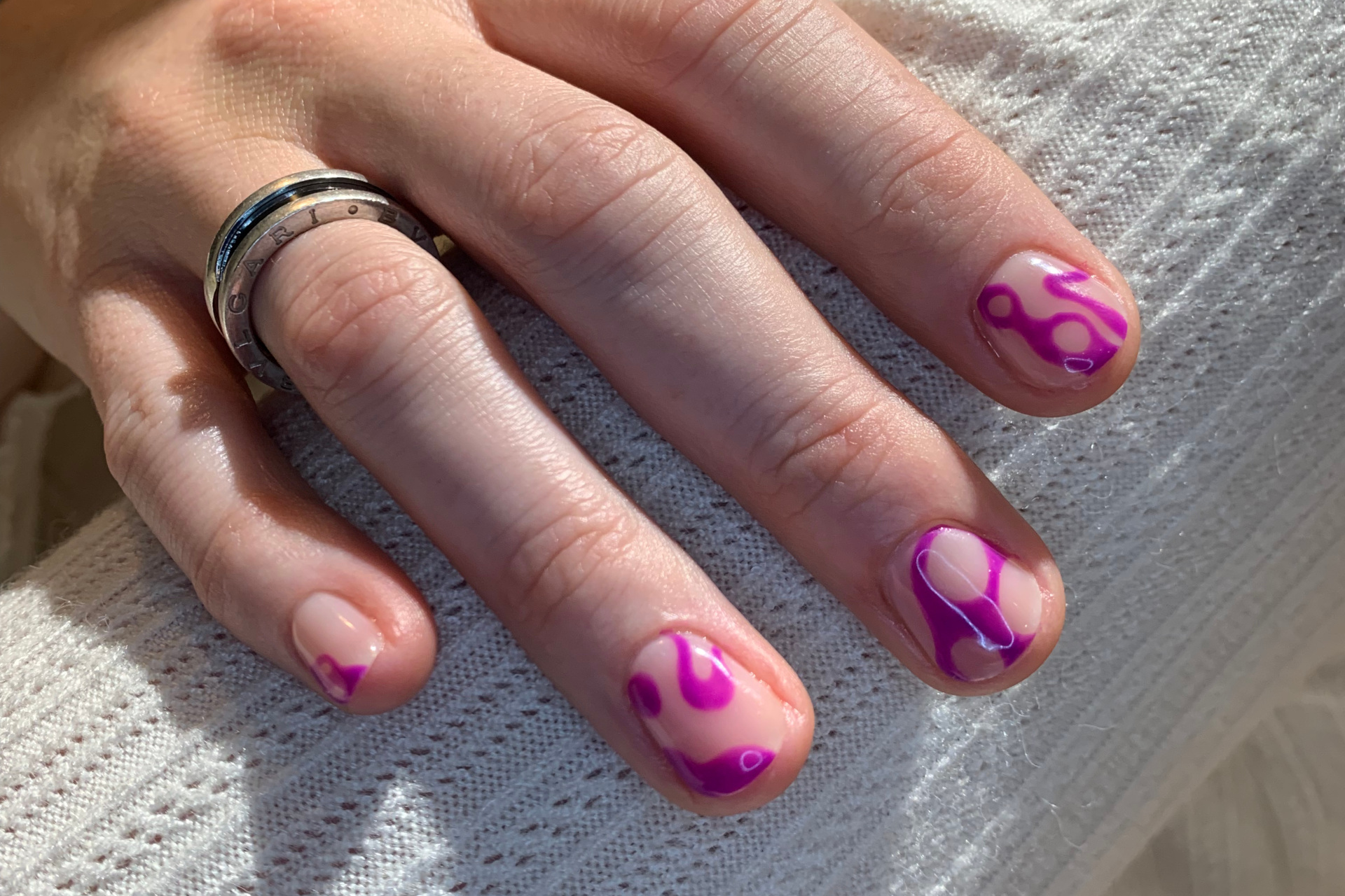 Close up of hand with pink lava lamp nails