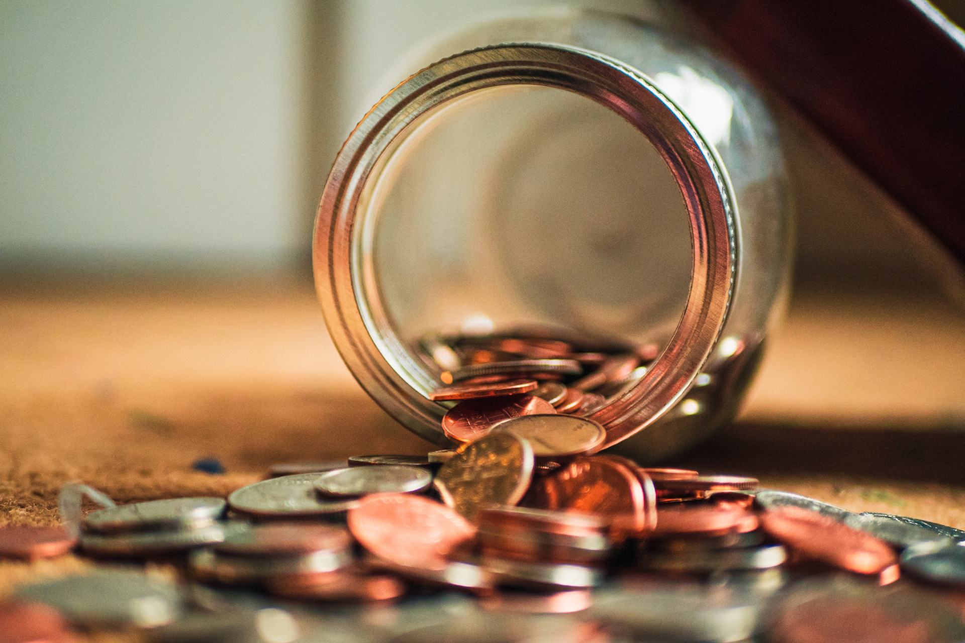 Jar tipped over with coins spilling out