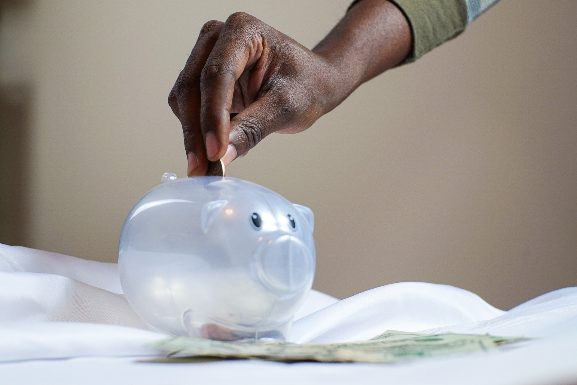 Hand putting money in piggy bank