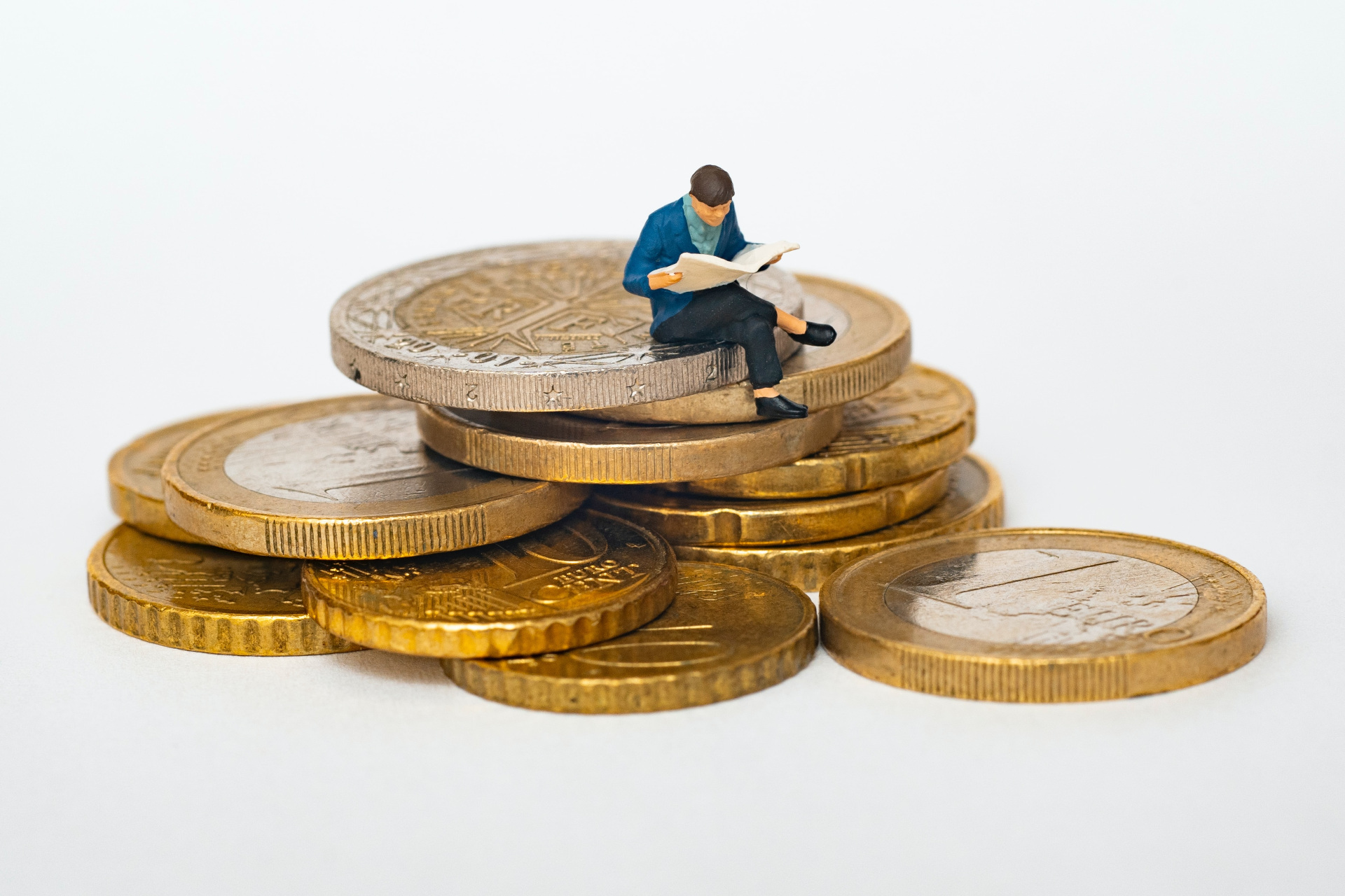 Miniature figure of a man sat on EU coins