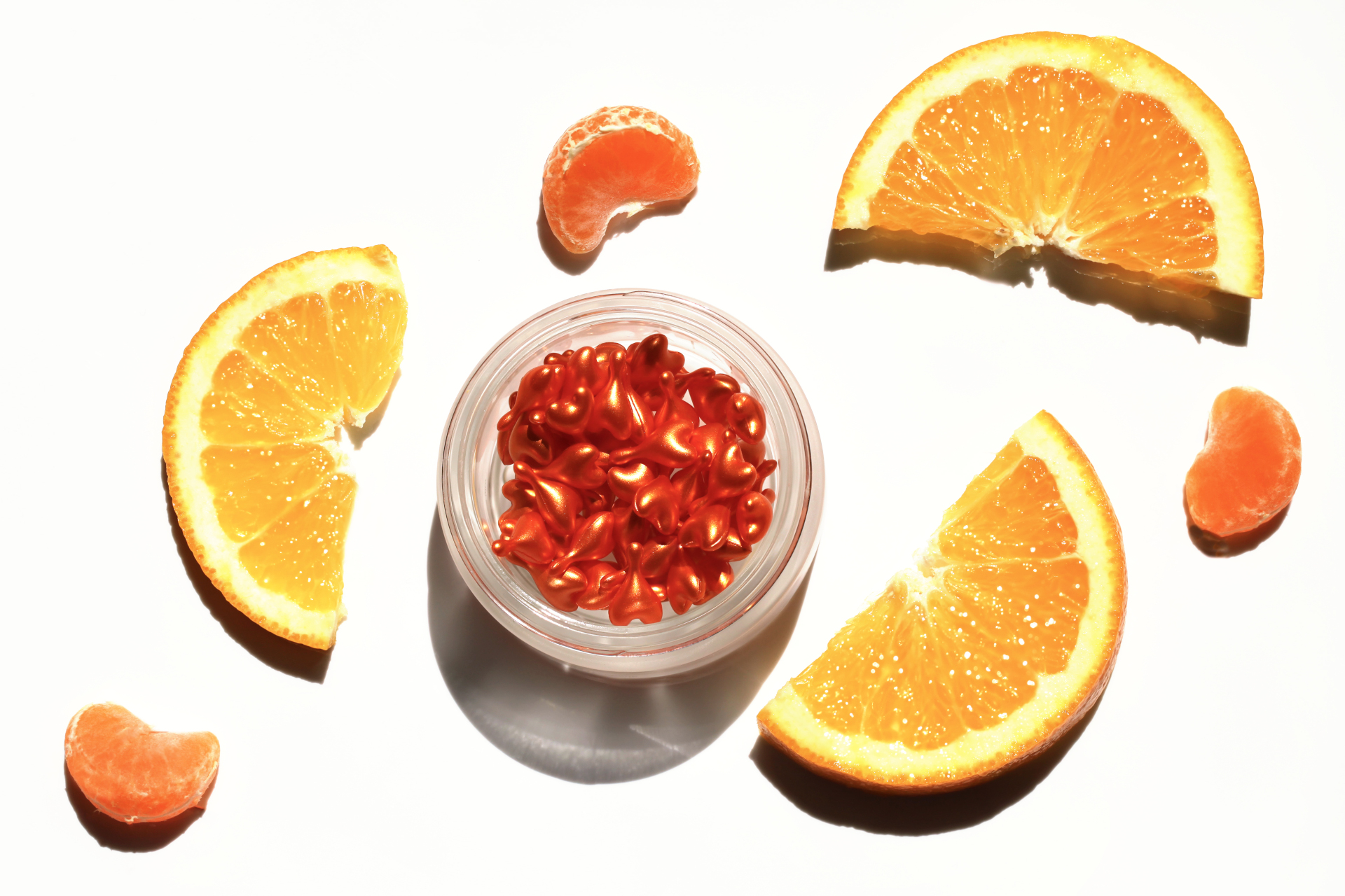 Tub of orange capsules surrounded by orange slices