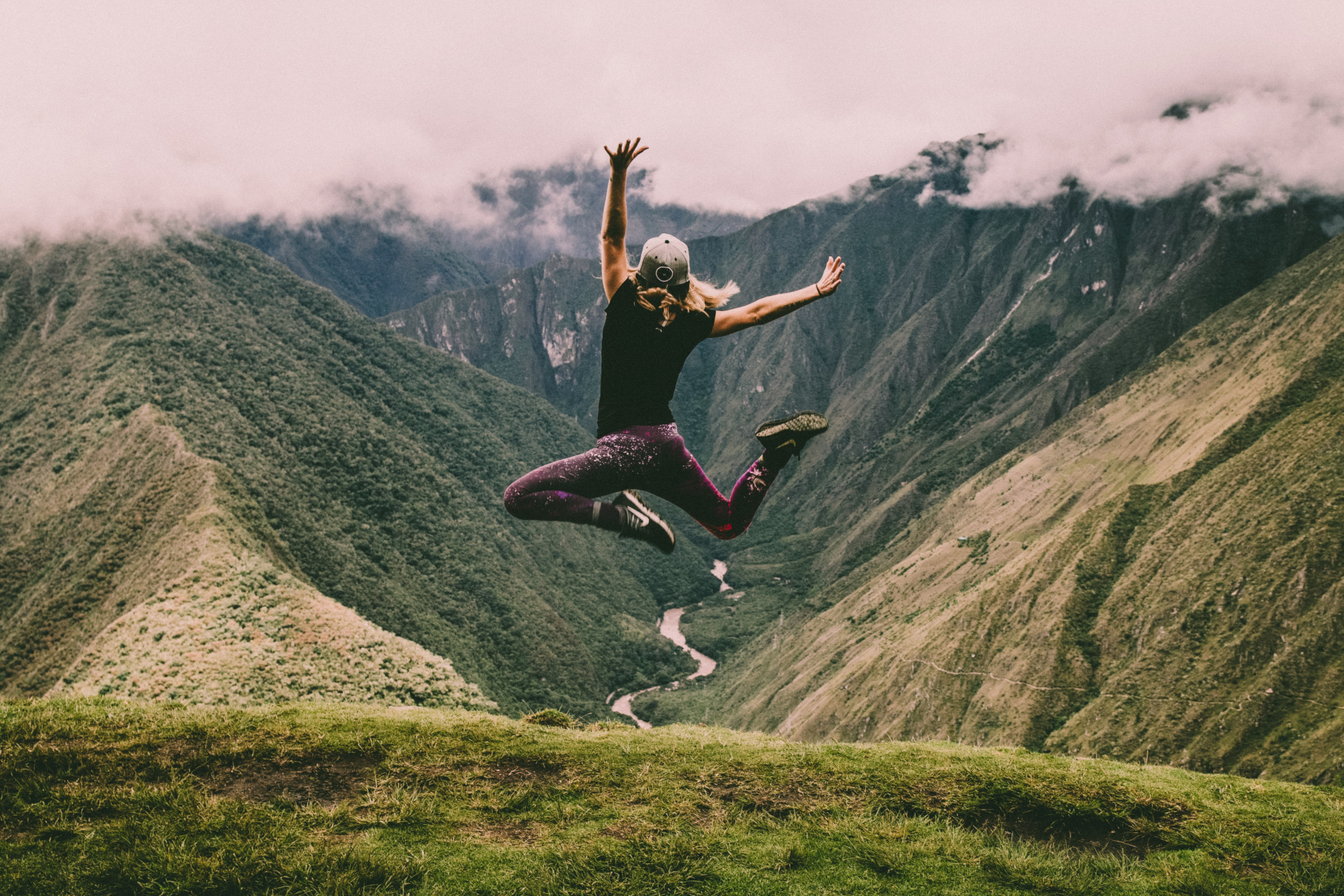 Woman jumping in front of hills
