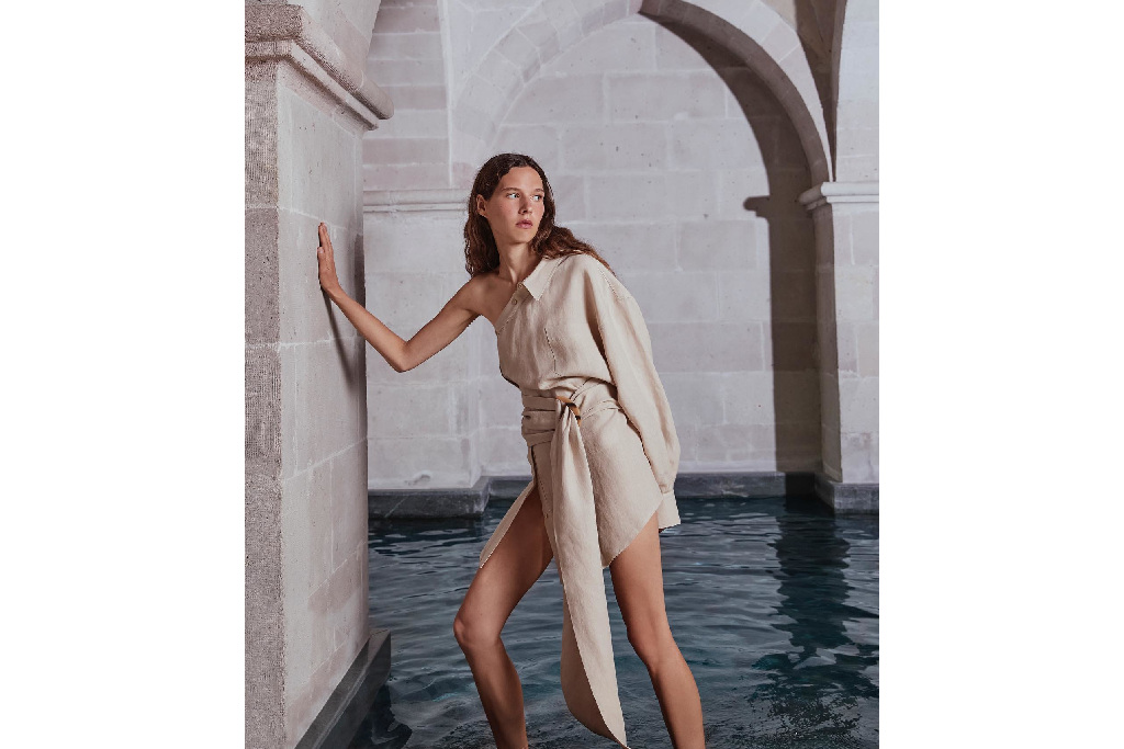 Woman leaning against wall in front of pool