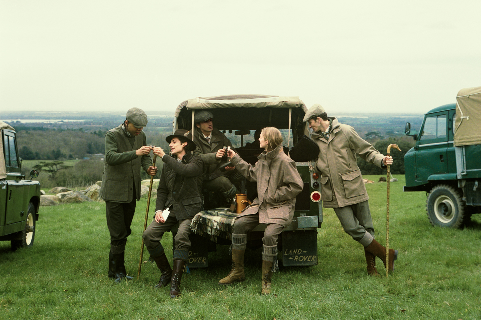 People in country clothing sitting in back of jeep