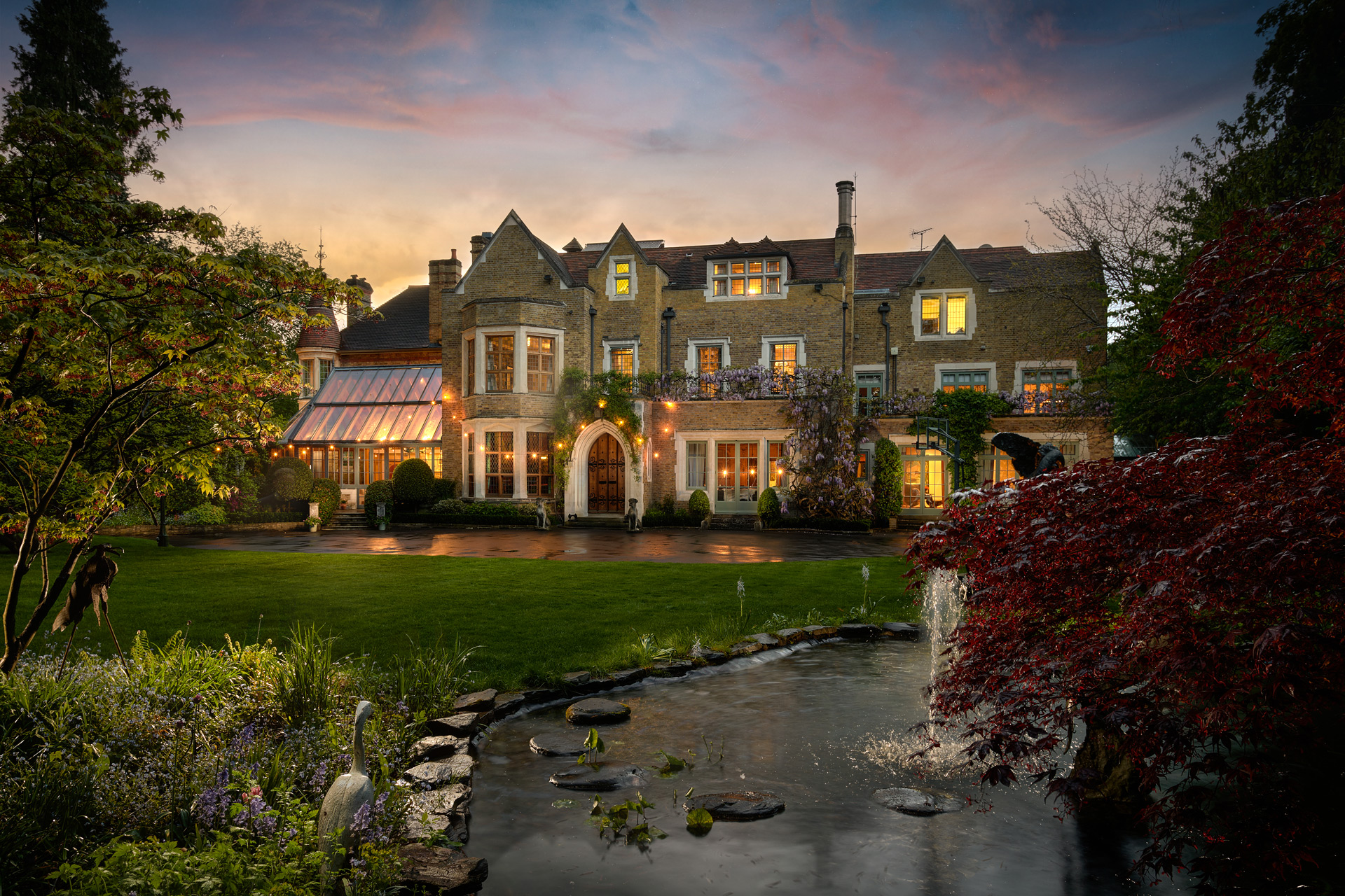 Exterior of large stone mansion at sunset