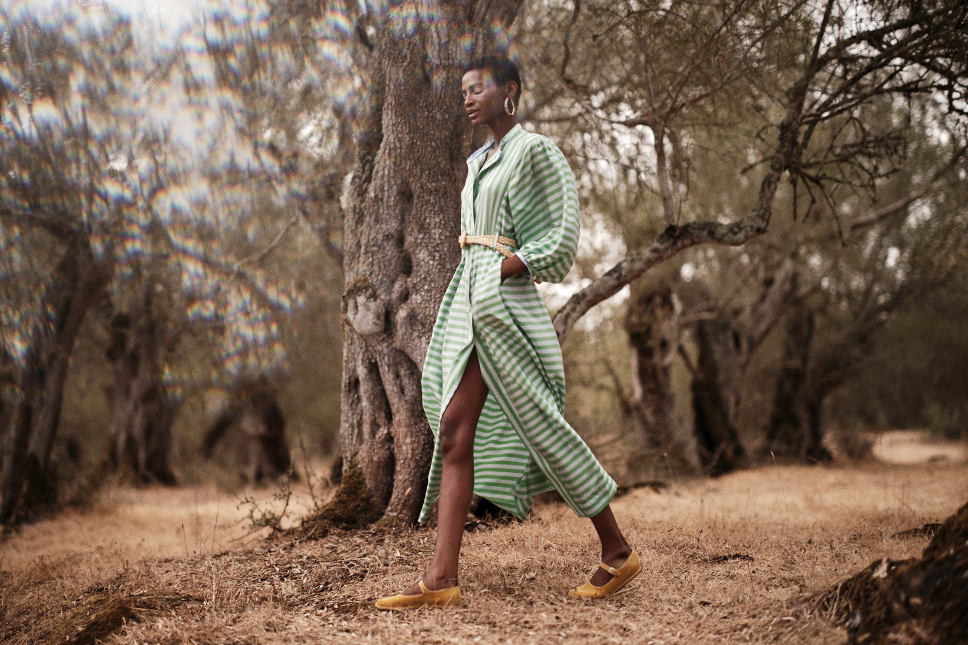 Woman walking through forest in green dress