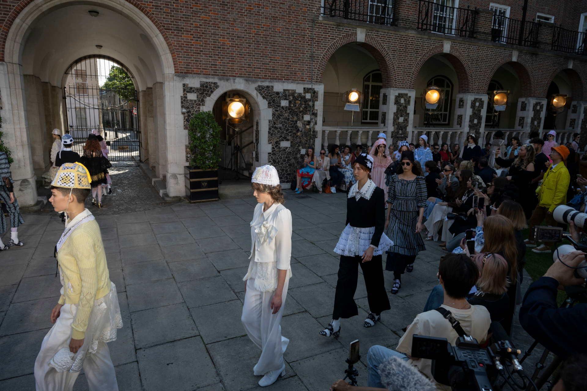 Models walking around courtyard at fashion week