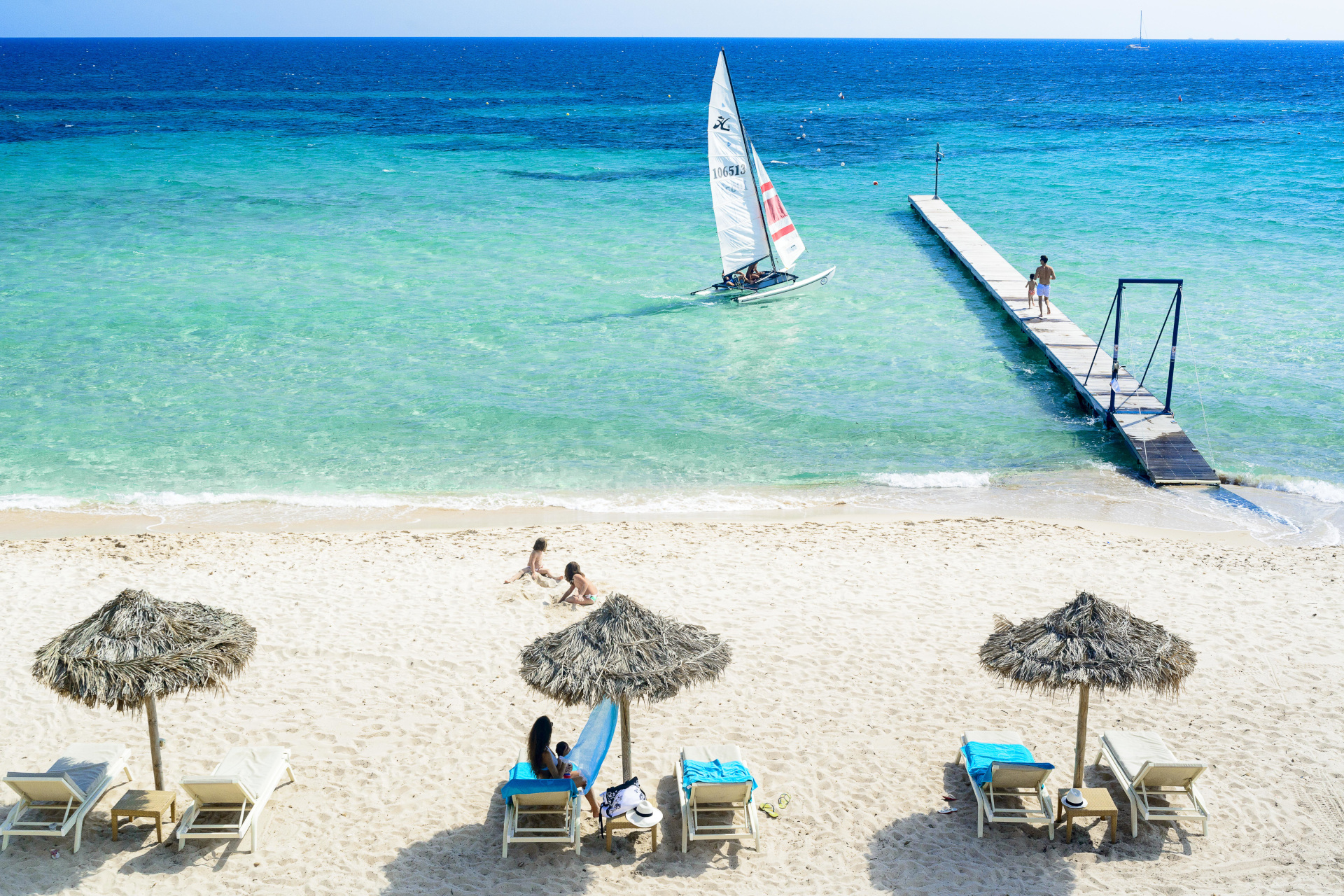 People sat on beach under umbrellas