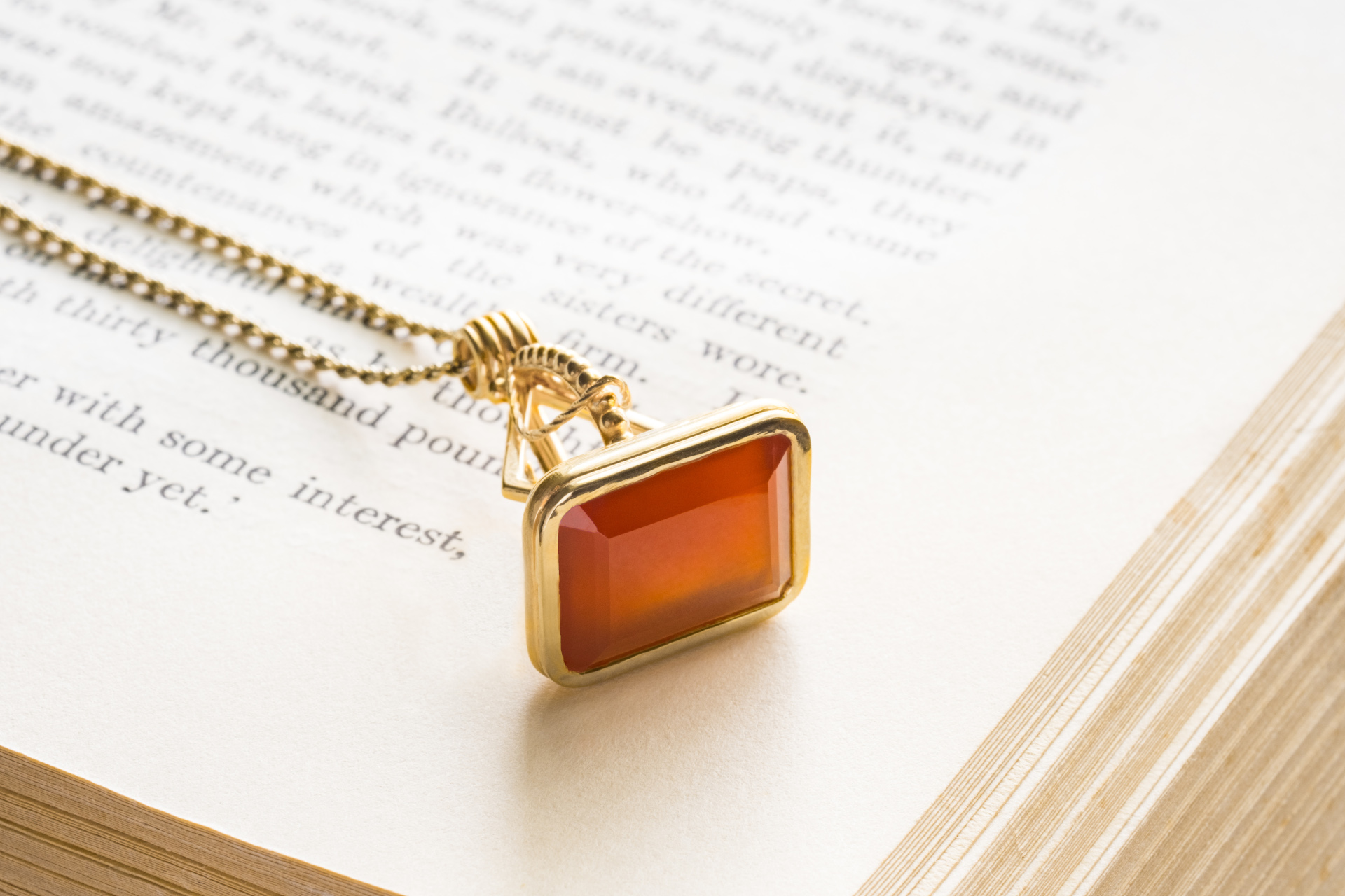 Orange gem necklace laid on open book