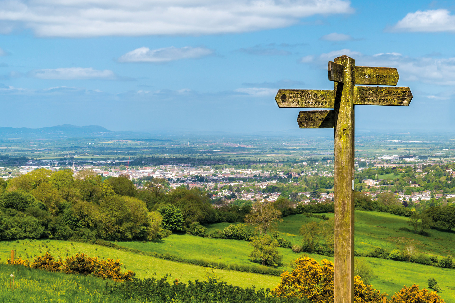 Wooden signpost on a hill in the countryside.