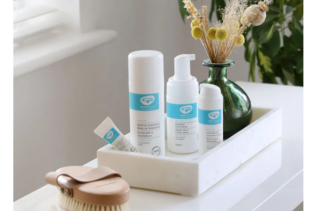 White skincare bottles in white tray on counter