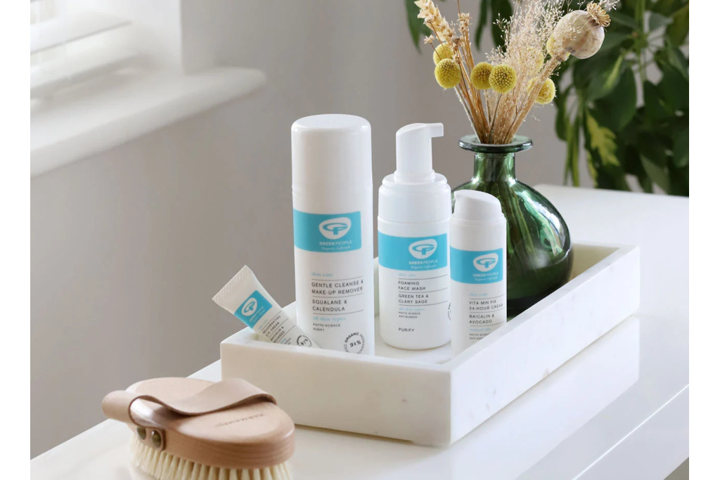 White skincare bottles in white tray on counter
