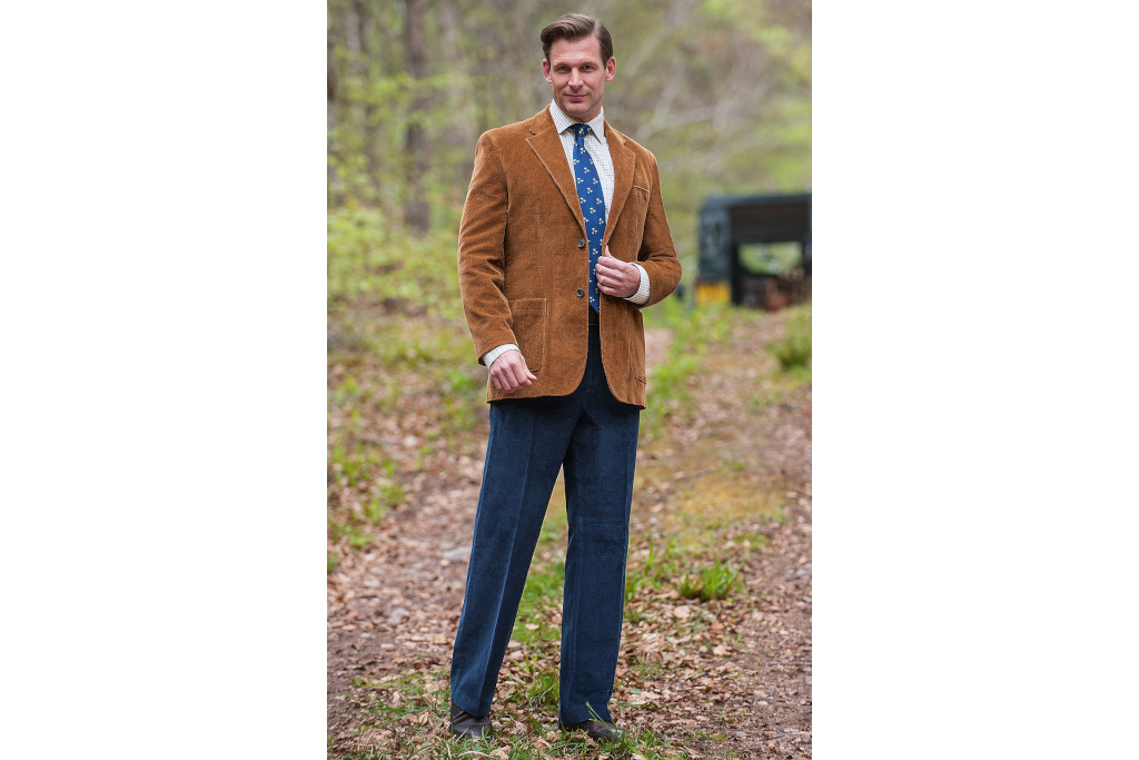 Man in brown blazer and navy cord trousers